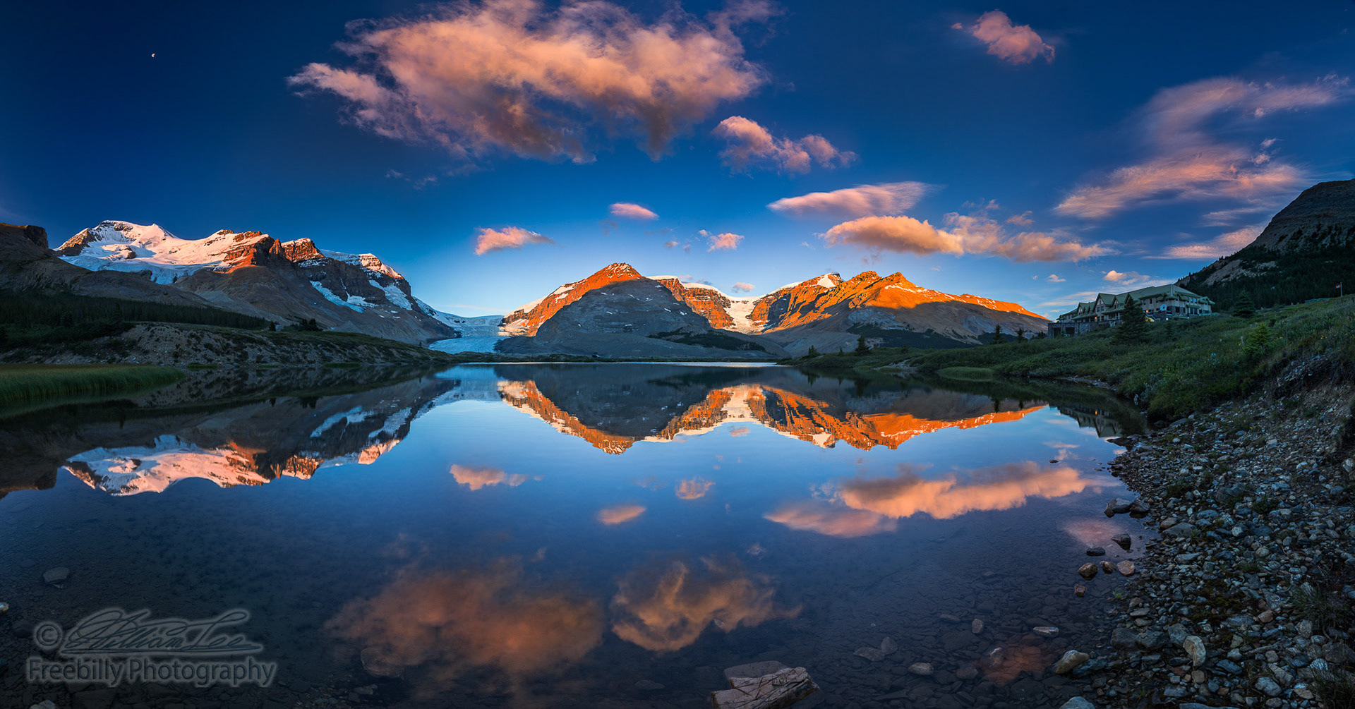 The panoramic view of snowy mountain and colorful clouds with lake reflections at ice field center of Jasper National Park. The left of the two glaciers is the most famous Athabasca glacier in Canada.