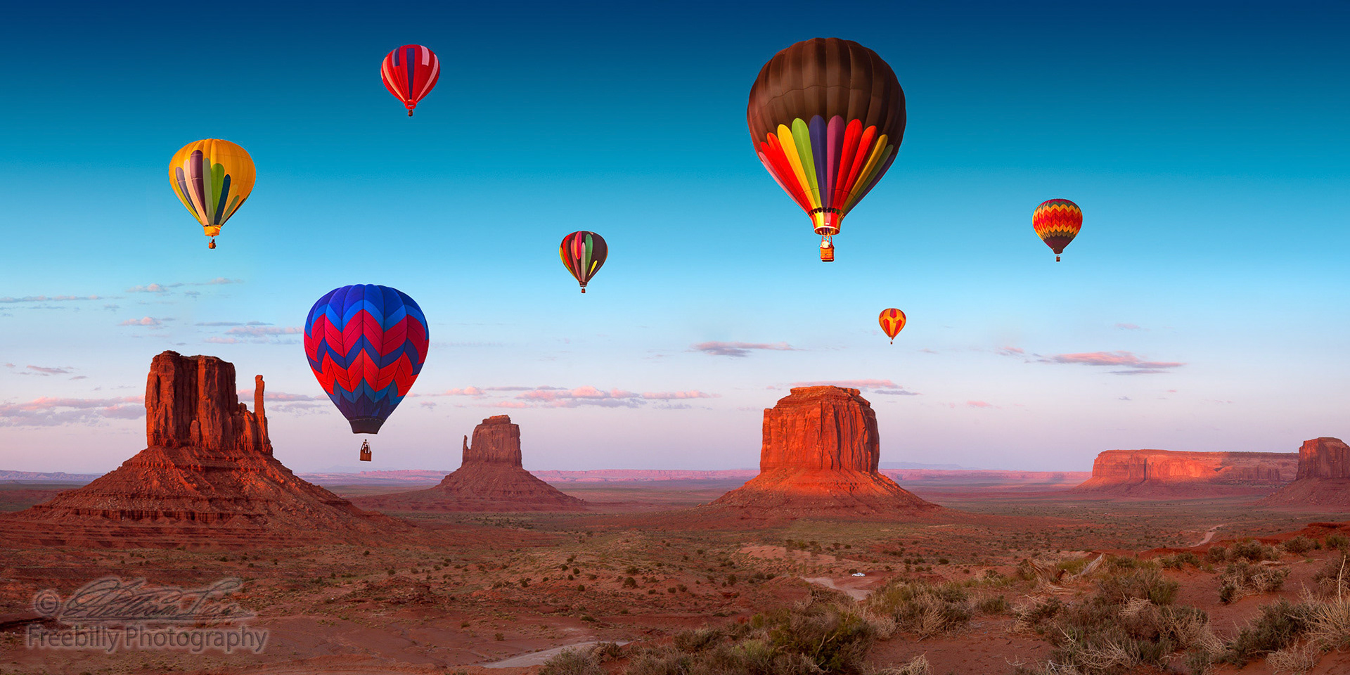 Some hot air balloons over Monument Valley at sunset hour. This is a 9740 pixel panoramic photograph.