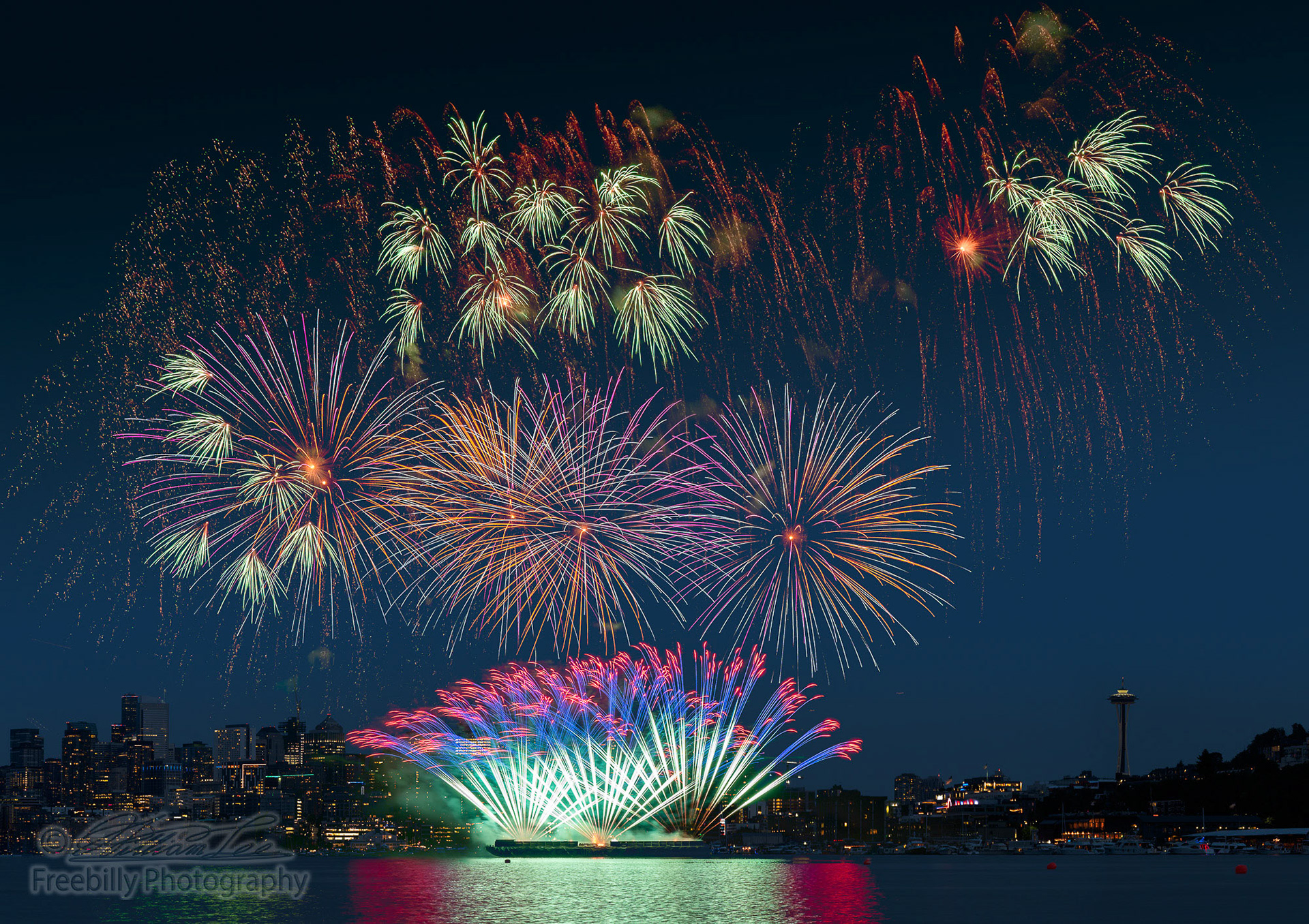A fine art epic Seattle fireworks display on celebration night, showing over the lake with multi color of reflection on water