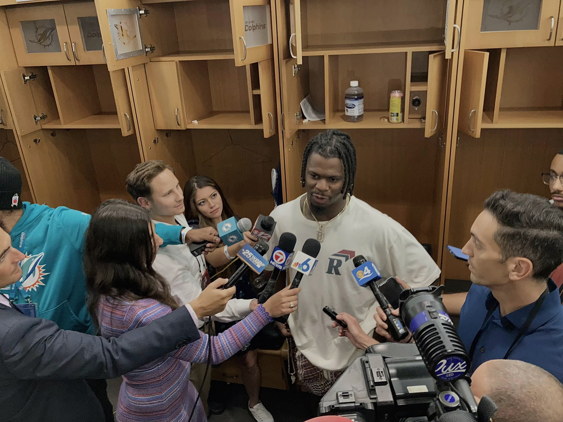 Reporters interview Miami Dolphin's LB Jerome Baker during media day.
