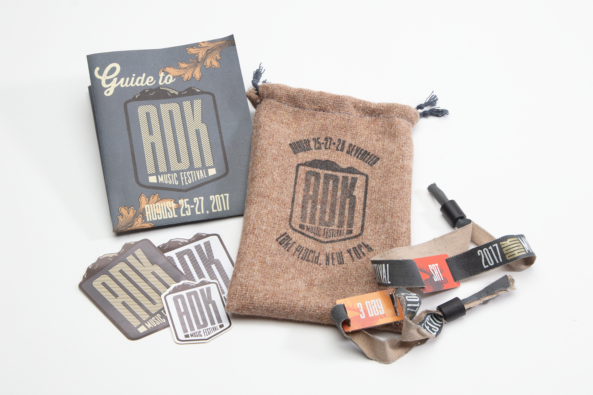Sticker pack, RFID bracelets, information foldout with lineup poster on back. All tucked inside a reusable branded pouch.