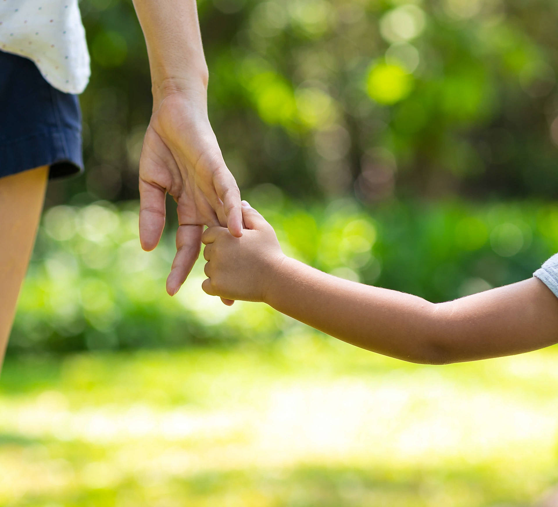 Enfant anxieux tenant la main d’un parent pour illustrer le stress et le rongement des ongles chez l’enfant