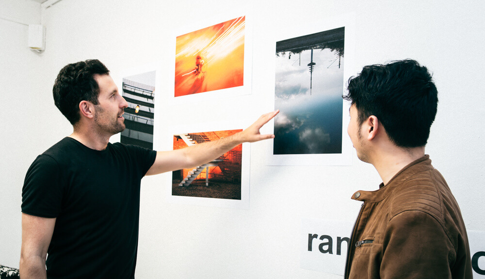 Künstler Philipp Eigner im Gespräch mit Besucher seiner Fotoausstellung. © My Lynh Pham