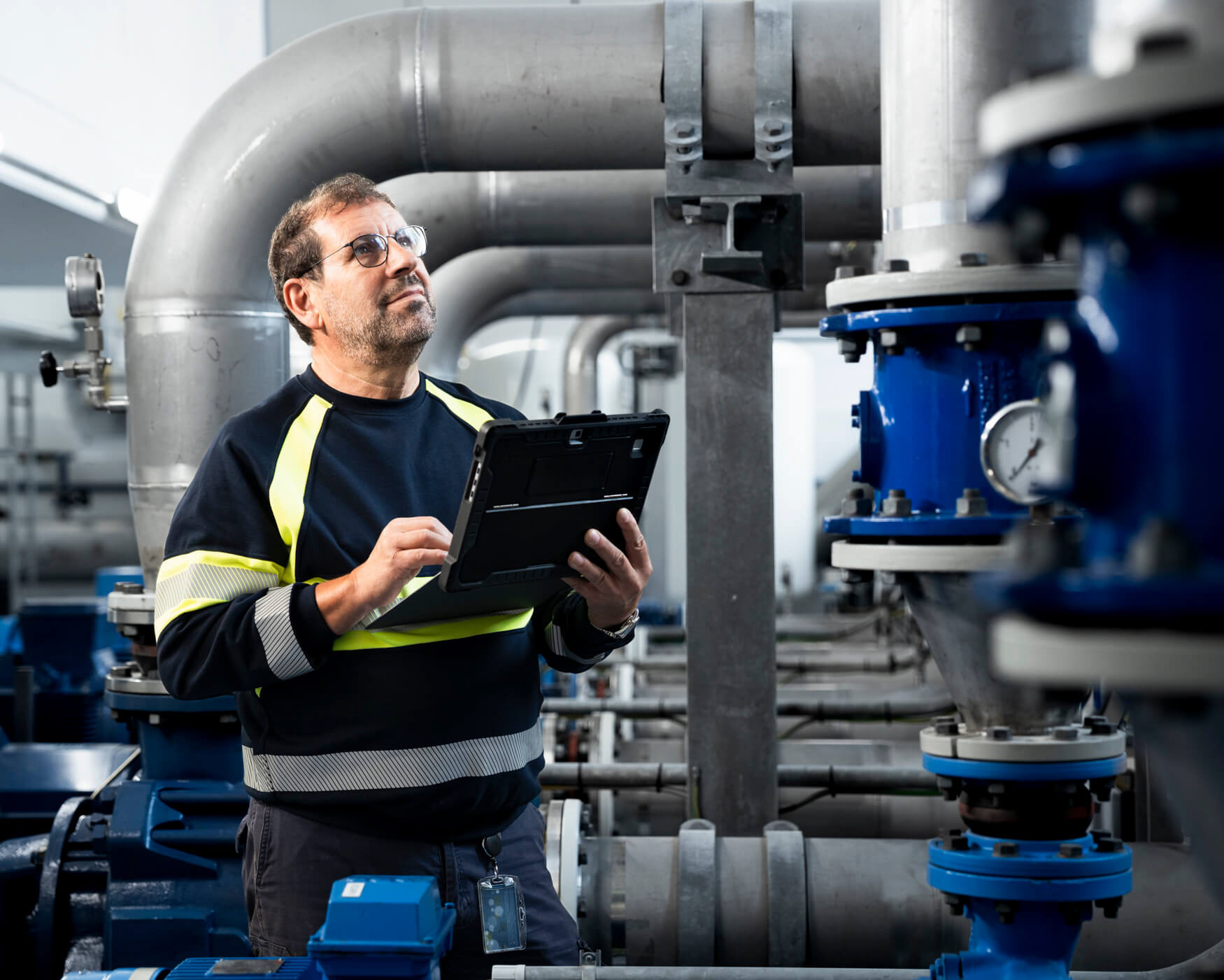 Wasserwerksmitarbeiter liest ein Manometer ab.