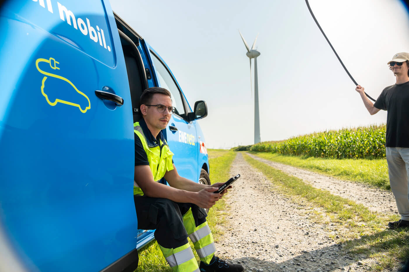 Assistent hält einen Diffusor, um das Licht, das im Windpark auf das Model fällt, abzumildern.