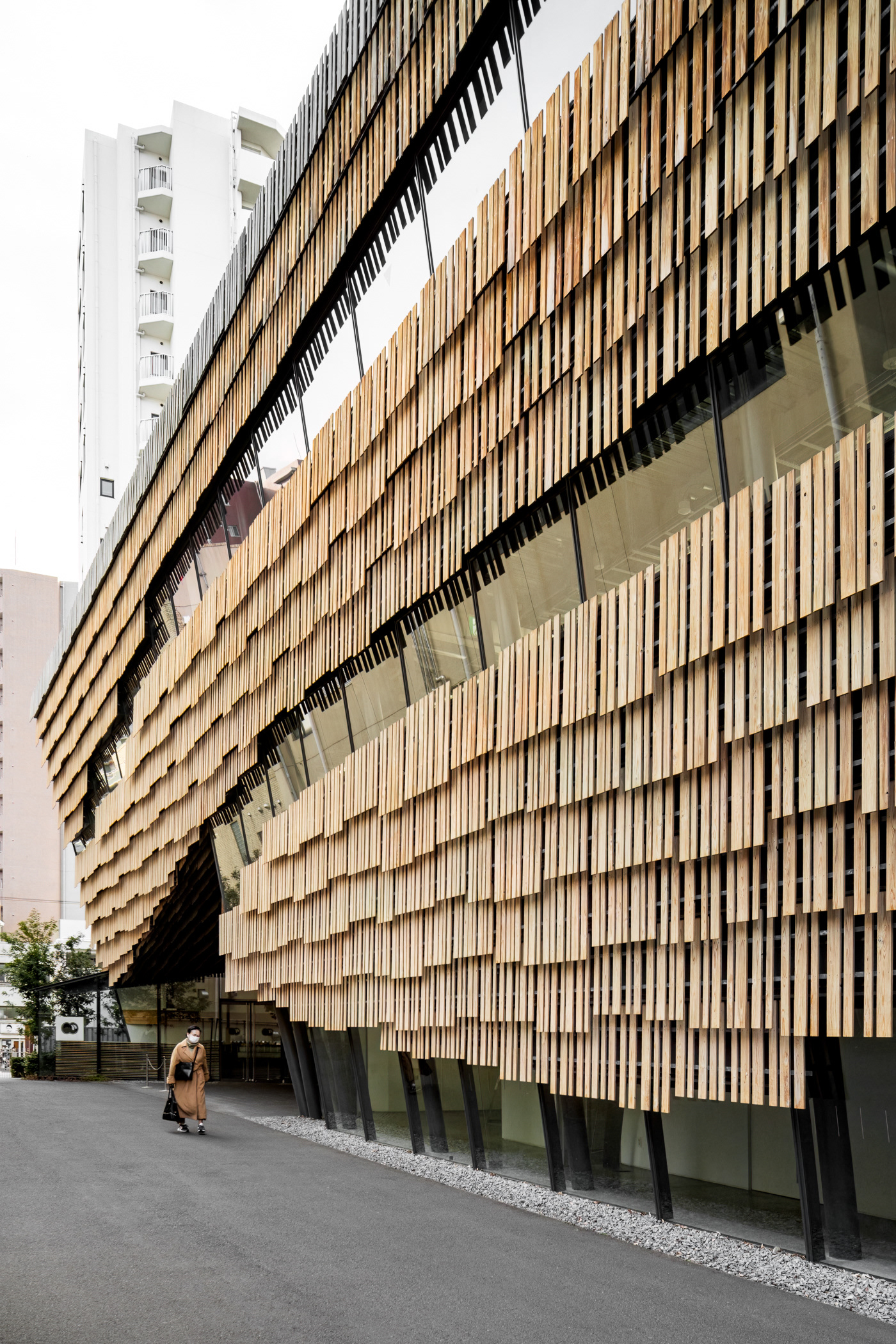Daiwa Ubiquitous Computing Research Building, designed by Kengo Kuma, is a cutting-edge architectural work in Tokyo, Japan, seamlessly blending technology, sustainability, and natural materials. Its distinctive layered wooden façade reflects Kuma’s philosophy of merging architecture with nature, creating a breathable, light-filtering structure. Inside, the design fosters an open, flexible environment that promotes innovation and collaboration. Captured by Sections Architectural and Interior Photography, showcasing its harmonious integration of wood, light, and modern technology.