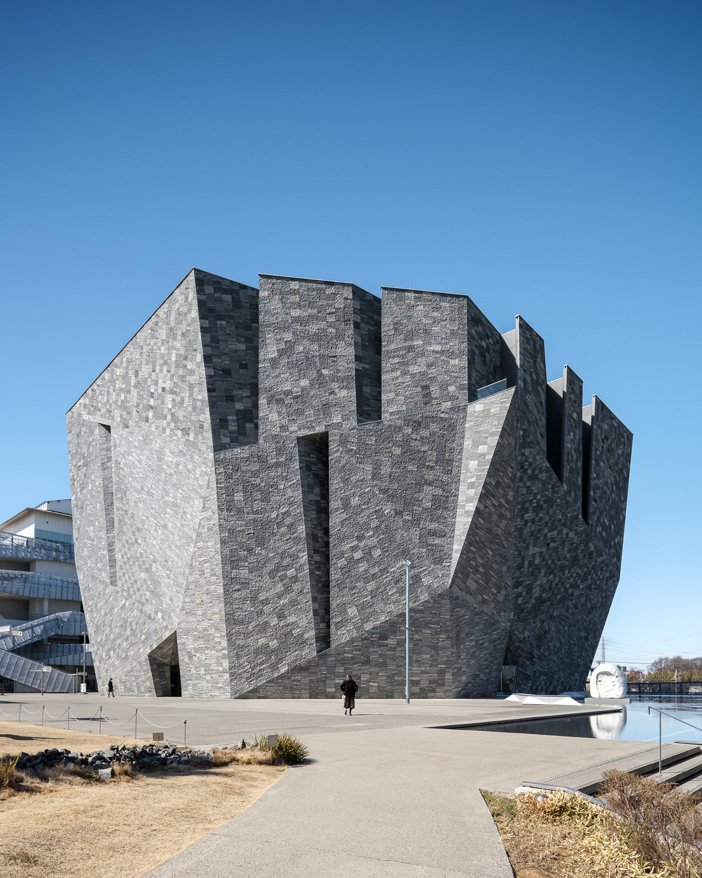 Designed by acclaimed architect Kengo Kuma, the Kadokawa Musashino Museum in Tokorozawa, Japan, is a striking fusion of art, culture, and architecture. Its sculptural stone façade and bold geometric forms create a captivating interplay of light, shadow, and texture. Through the lens of Sections Architectural and Interior Photography, we highlight the museum’s dynamic spaces and innovative design.