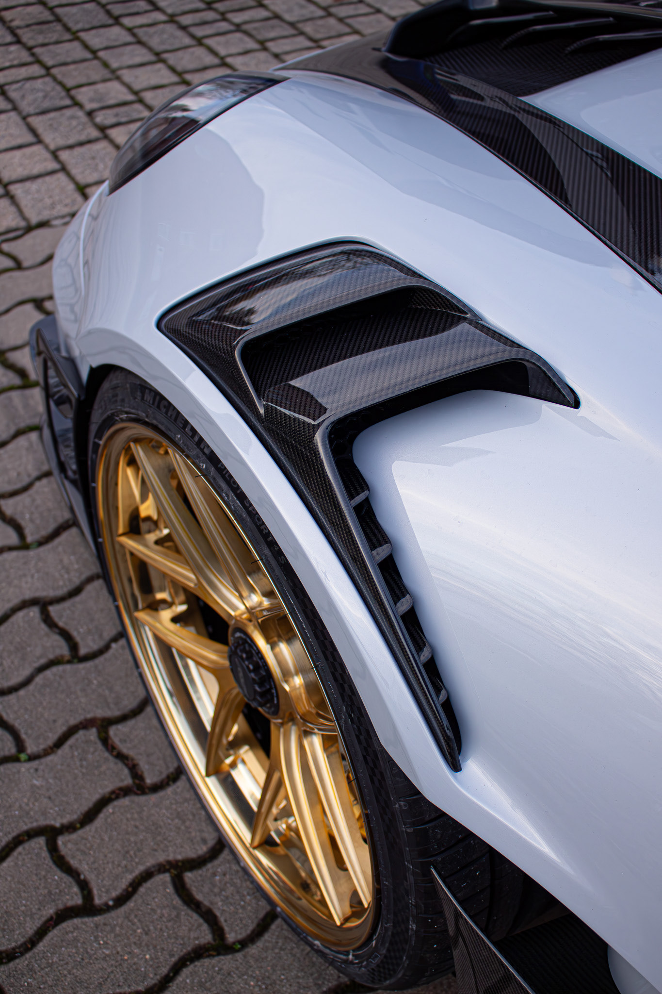 Goldenes Radwerk als Kontrast zur kühlen Karosserie – Kunst und Technik in Symbiose.