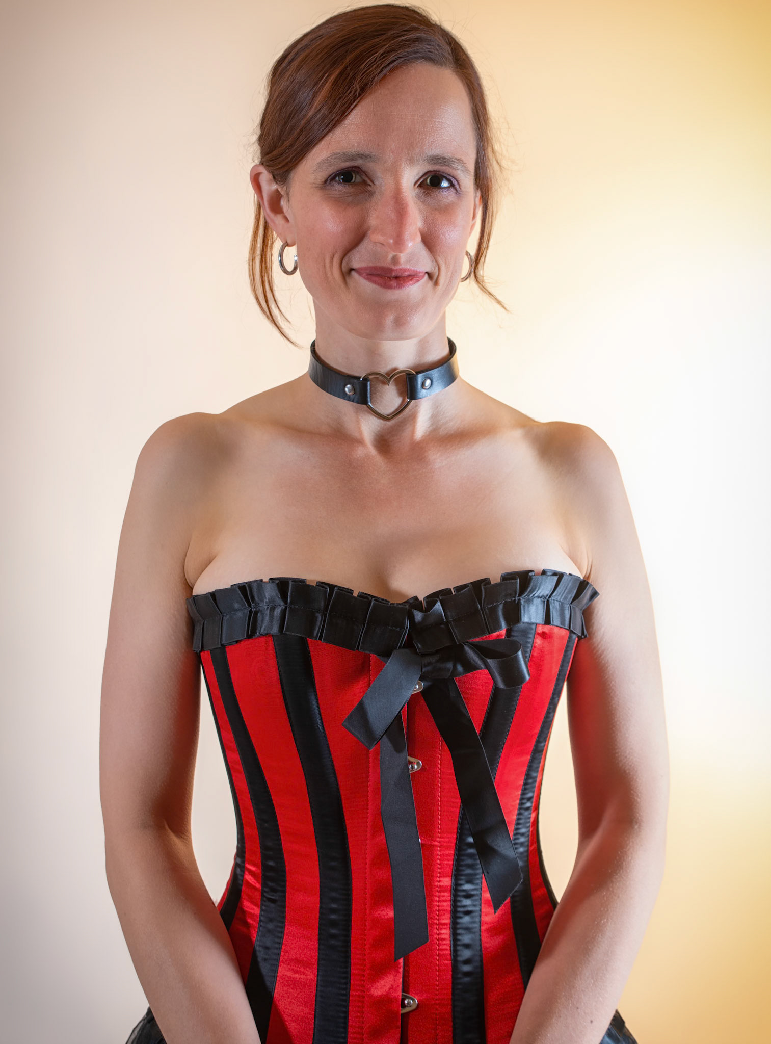 Western Corsetry - Fainting on the Fainting Couch: Bringing back out the western themed corset outfit for a final run at studio shots with the seamless backdrop. Godox v1 with 7" reflector front left, 30x120 softbox with another Godox V1 right side, and Godox AD200 w/ Yellow gel lighting the backdrop.