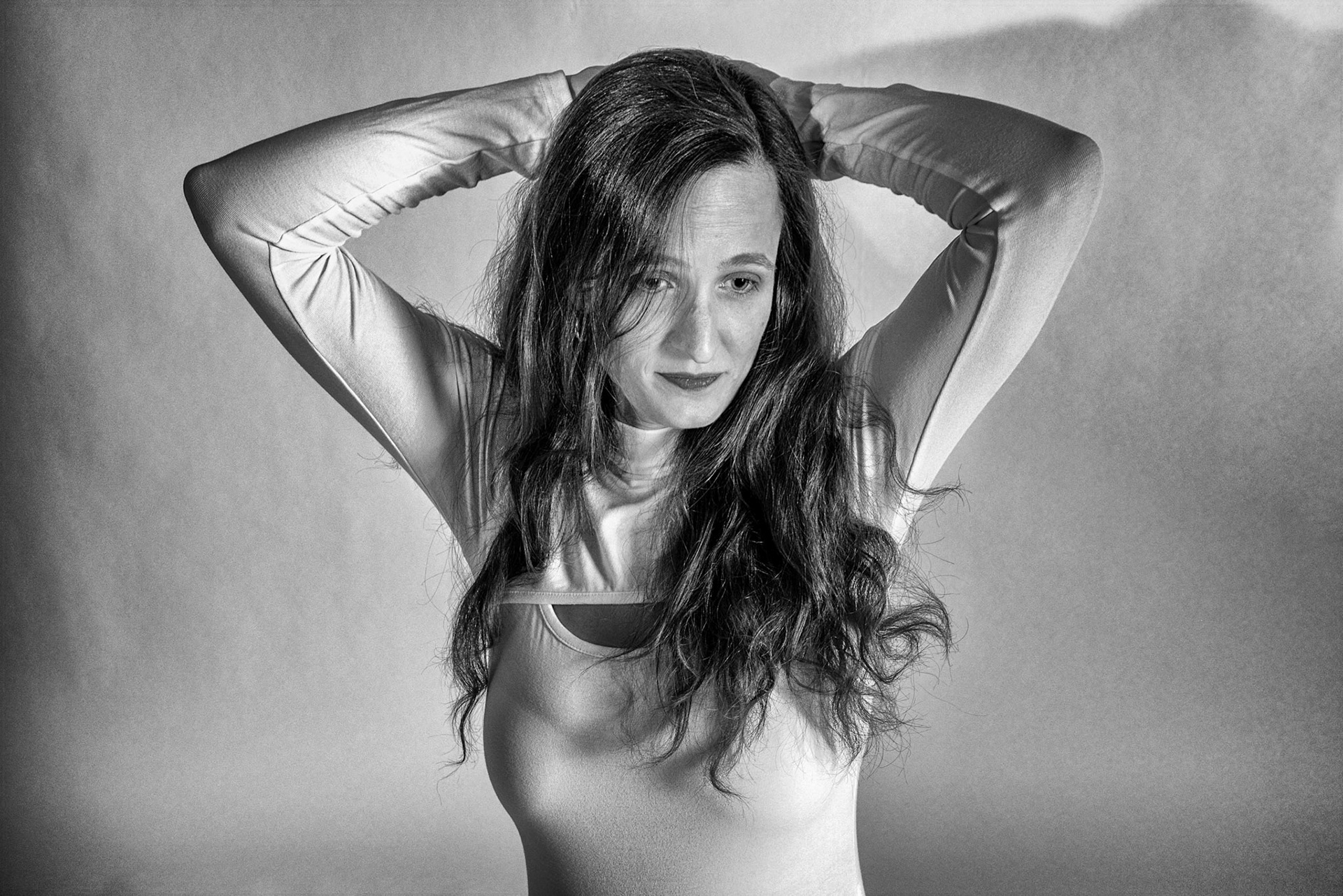 Super Heroine - Defiant Surrender (B&amp;W): Trying out a basic superheroine costume. Godox v1 w/ snoot for face, v1 w/ 30x120cm for general, and AD200 w/ red gel for backdrop.