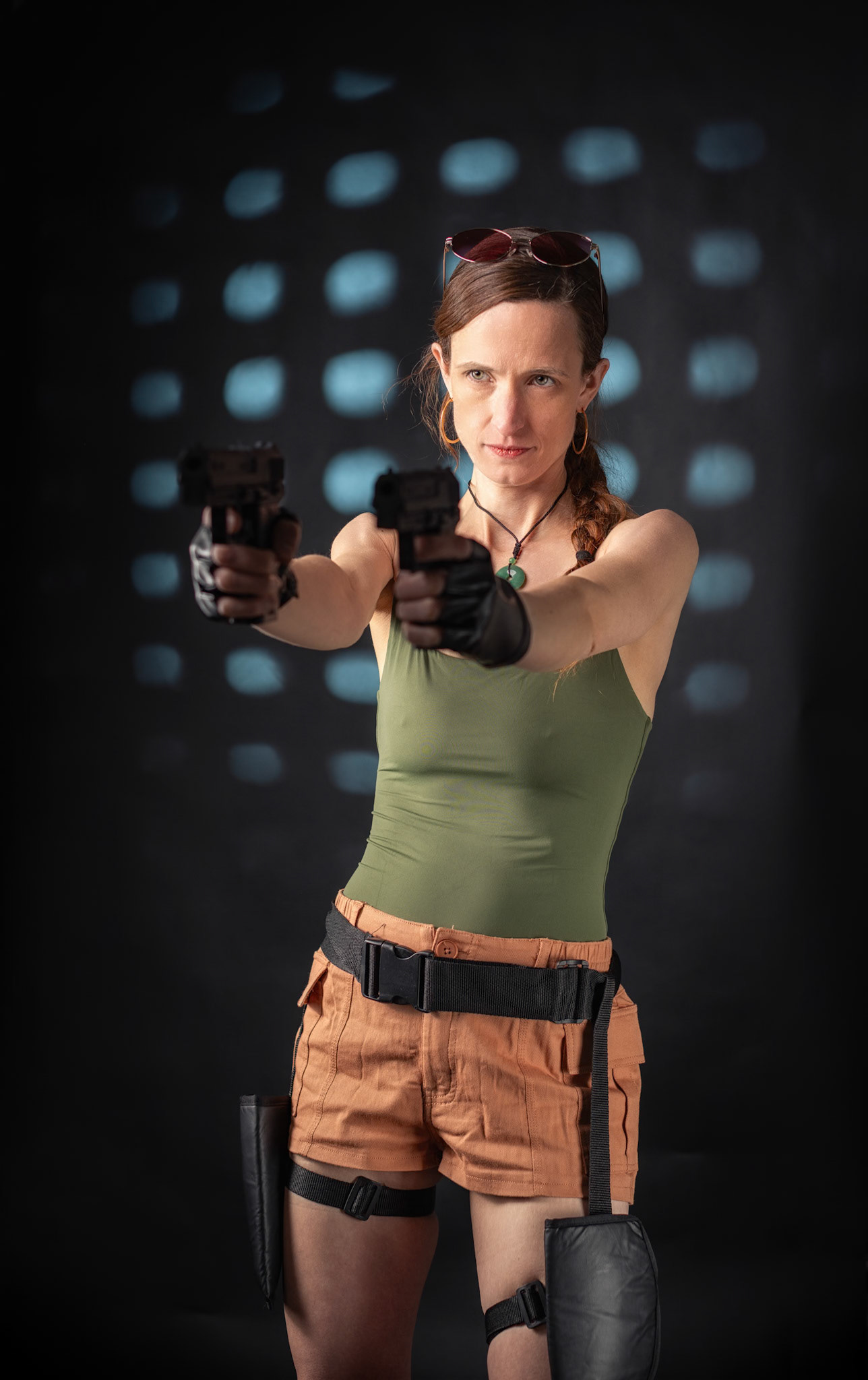 Lara Croft: Locked on Target - A cinematic Lara Croft cosplay portrait inspired by Tomb Raider. With dual pistols drawn and eyes locked forward, this studio setup captures the intensity and confidence of the iconic adventurer. Custom 3D-printed prop weapons and dramatic rim lighting add depth and tension, bringing the action-game energy into a controlled studio environment.Lit with a Flashpoint XPlor 600 key, Godox AD200/V1-P fill, and a gobo backlight for that signature cinematic edge.