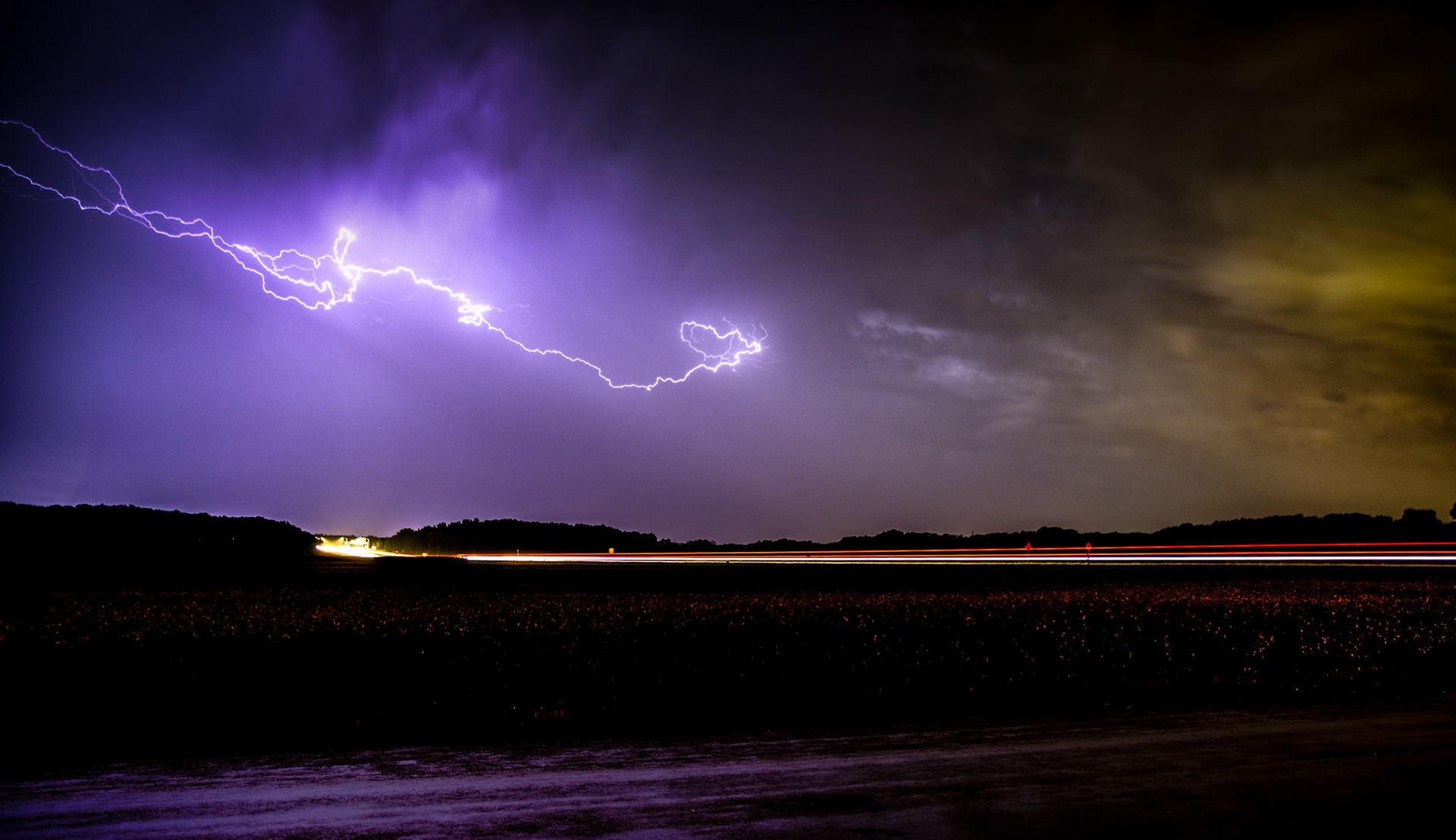 Lightning burst over traffic racing home: My second night of storm chasing this week, I attempted to capture some of the awesome lightning show. For this one, I couldn't decide if I liked it better in black and white or color.