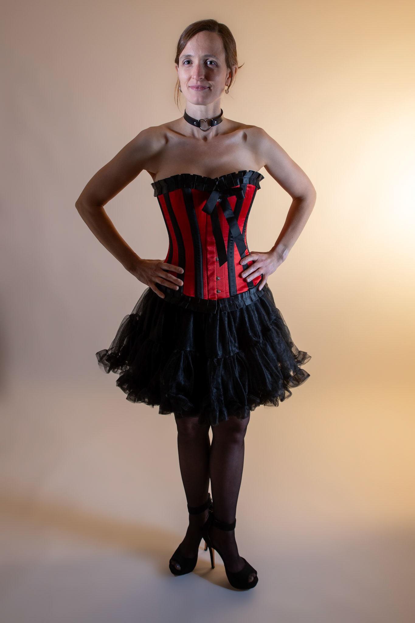 Western Corsetry - Posed: Bringing back out the western themed corset outfit for a final run at studio shots with the seamless backdrop. Godox v1 with 7" reflector front left, 30x120 softbox with another Godox V1 right side, and Godox AD200 w/ Yellow gel lighting the backdrop.