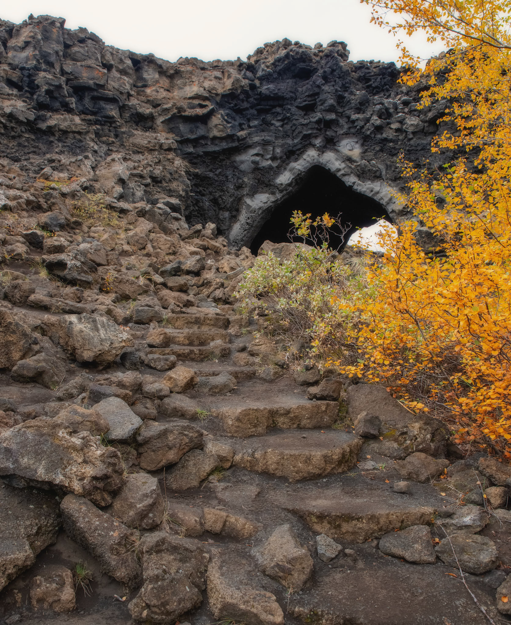 The formation of these extraordinary lava cliffs and pillars stems from molten lava flowing over a pond in the eruption of Lúdentaborgir and Þrengslaborgir some 2300 years ago. The molten lava trapped the water underneath and steam issued through vents in the lava and formed these pillars, which then remained standing even after the pond and the crust around them had disappeared. If you walk up the steps to the church you will notice that it is a cave open in both ends with a high-dome shaped roof. It looks like it is man-made, but it is actually a lava cave, which looks a little like a Gothic church. Re-edited in 2025 to utilize new techniques learned since 2018.