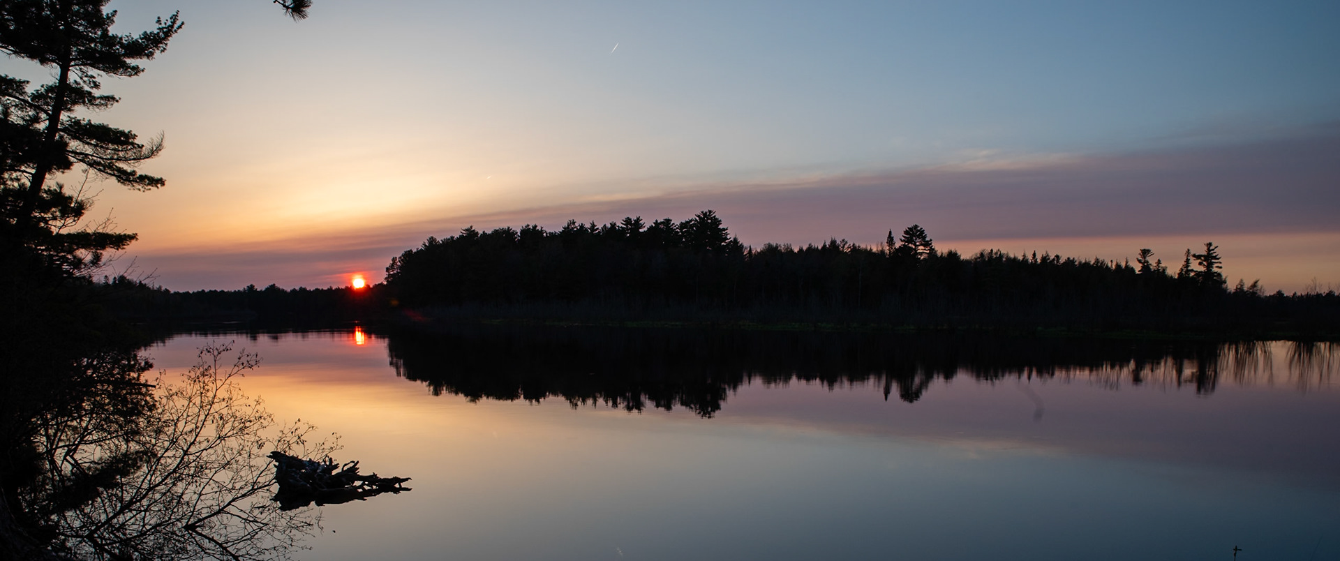Taquamenon Reflections: Capturing the sunset amid the wildfire smoke over the glass smooth Taquemenon River.