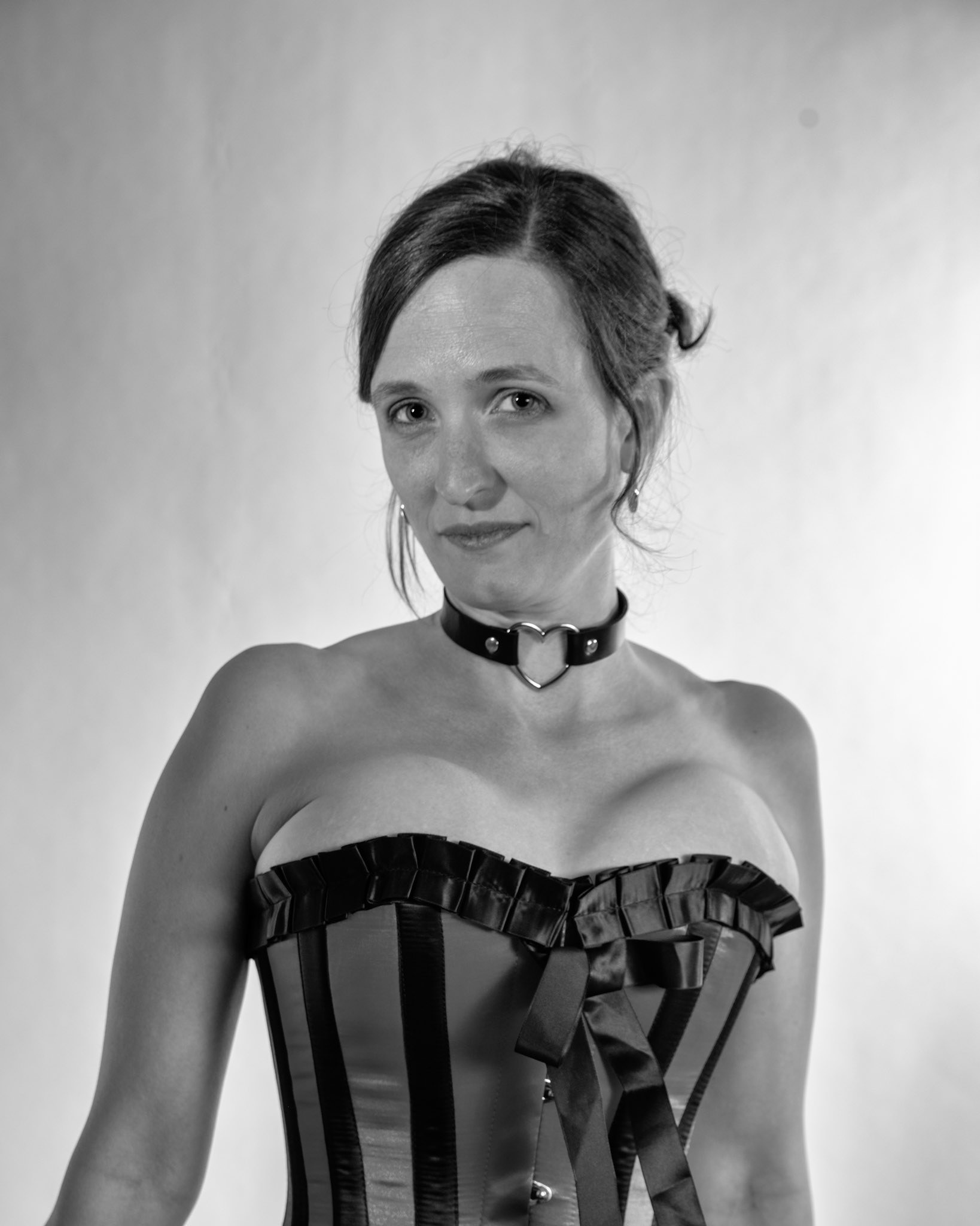 Western Corsetry - Close Up (B&amp;W): Bringing back out the western themed corset outfit for a final run at studio shots with the seamless backdrop. Godox v1 with 7" reflector front left, 30x120 softbox with another Godox V1 right side, and Godox AD200 w/ Yellow gel lighting the backdrop.