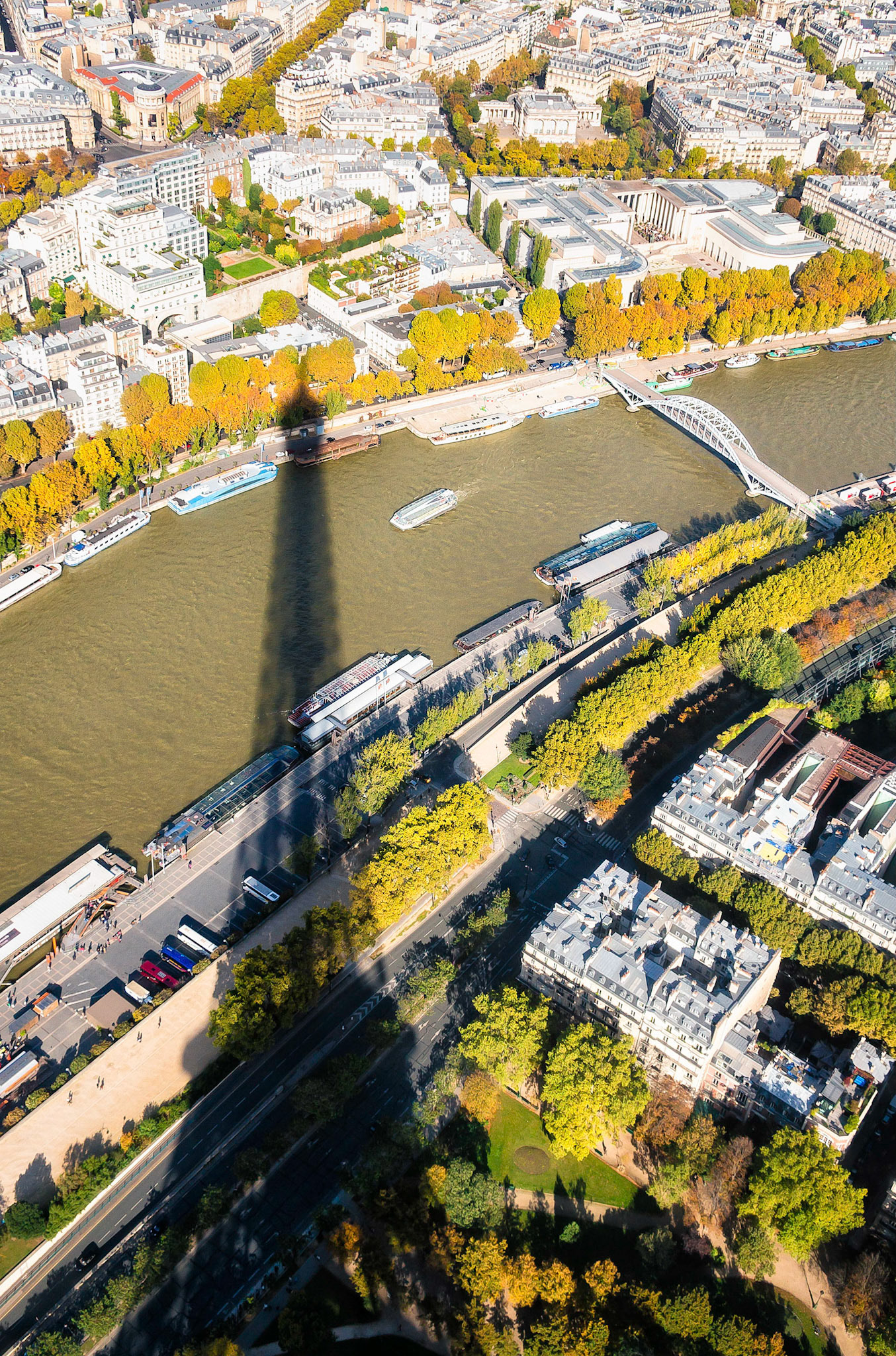 On this fine autumn afternoon, the iconic Eiffel Tower casts its long shadow over the Seine River in Paris, France.