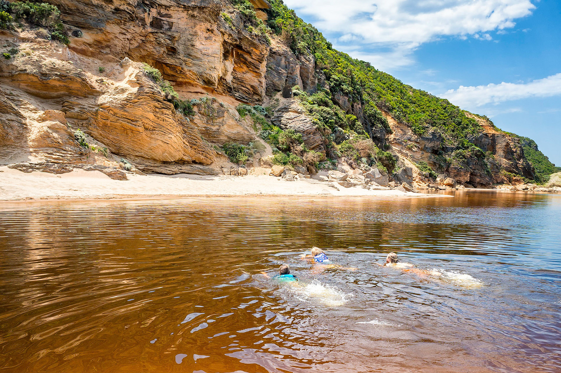 Children enjoying an outing in the great outdoors, swim across the Aire River in Victoria, Australia  on a fine summer afternoon.