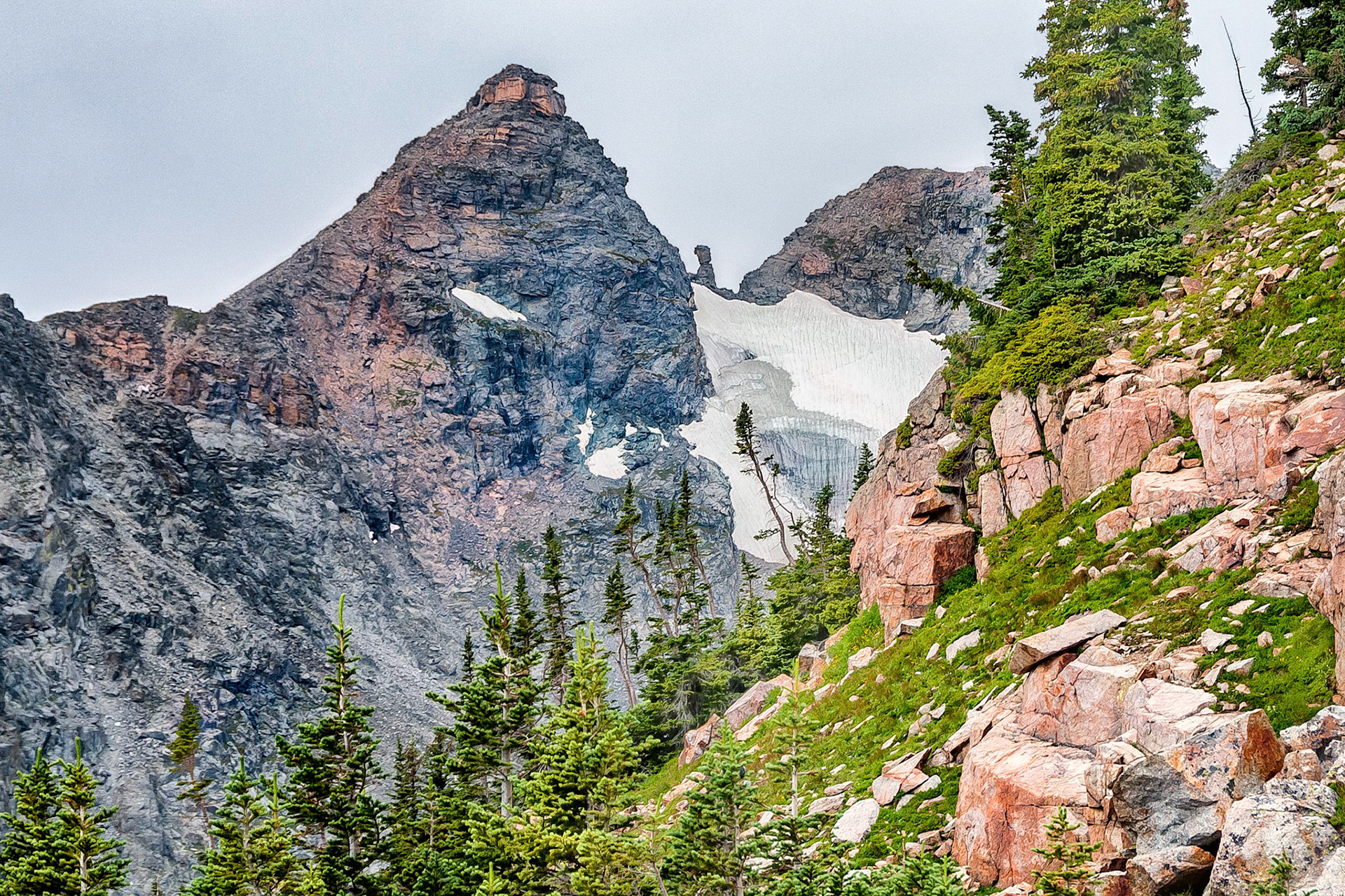 The rugged scenic terrain of the Indian Peaks Wilderness Area in the Roosevelt National Park of Colorado, USA, is dominated by a jagged skyline along the Continental Divide. Here, the Navajo and Apache Peaks on the ridge line stand witness to the power of glacial erosion and the passing of time. Remnants of a collapsed cornice form large icicles as the snow field above melts over a cliff face.