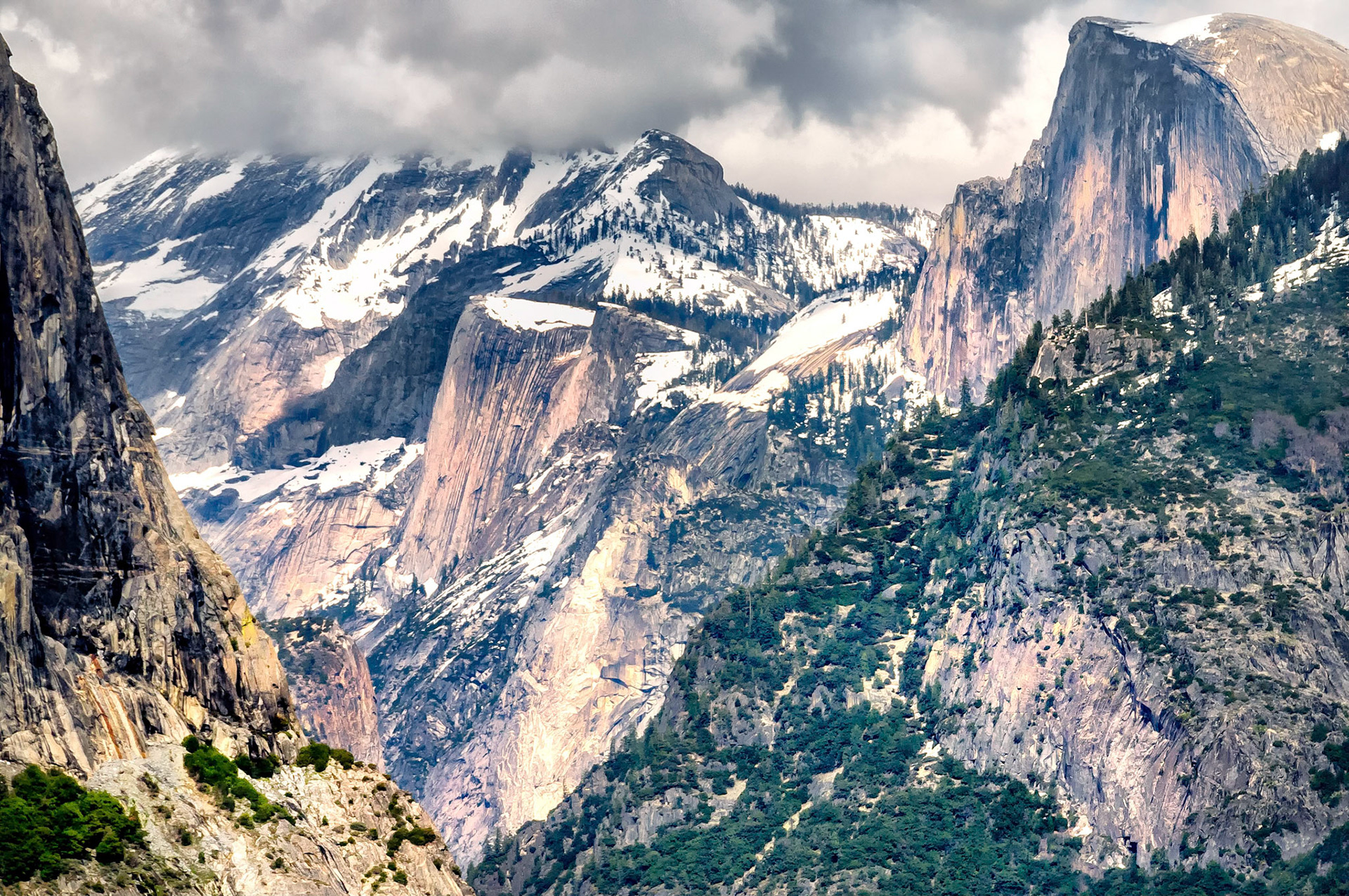 A gloomy mood prevails in the Yosemite Valley of California, USA as storm clouds gather behind the iconic Half Dome. The Yosemite Valley was carved from granite rocks by glacial action that left these dramatic landscapes.