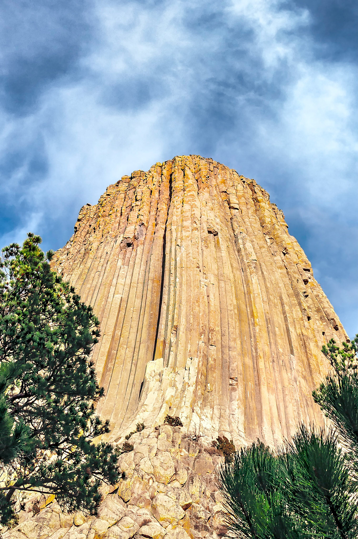 Devils Tower is located in north-eastern Wyoming and became the first National Monument in the United States, (1906). The formation is a volcanic  intrusion that remains after surrounding sandstone layers eroded away. It rises 1,267 feet (386 m) above the Belle Fourche River and is popular with climbers. The tower is also a sacred site to many Native American tribes.