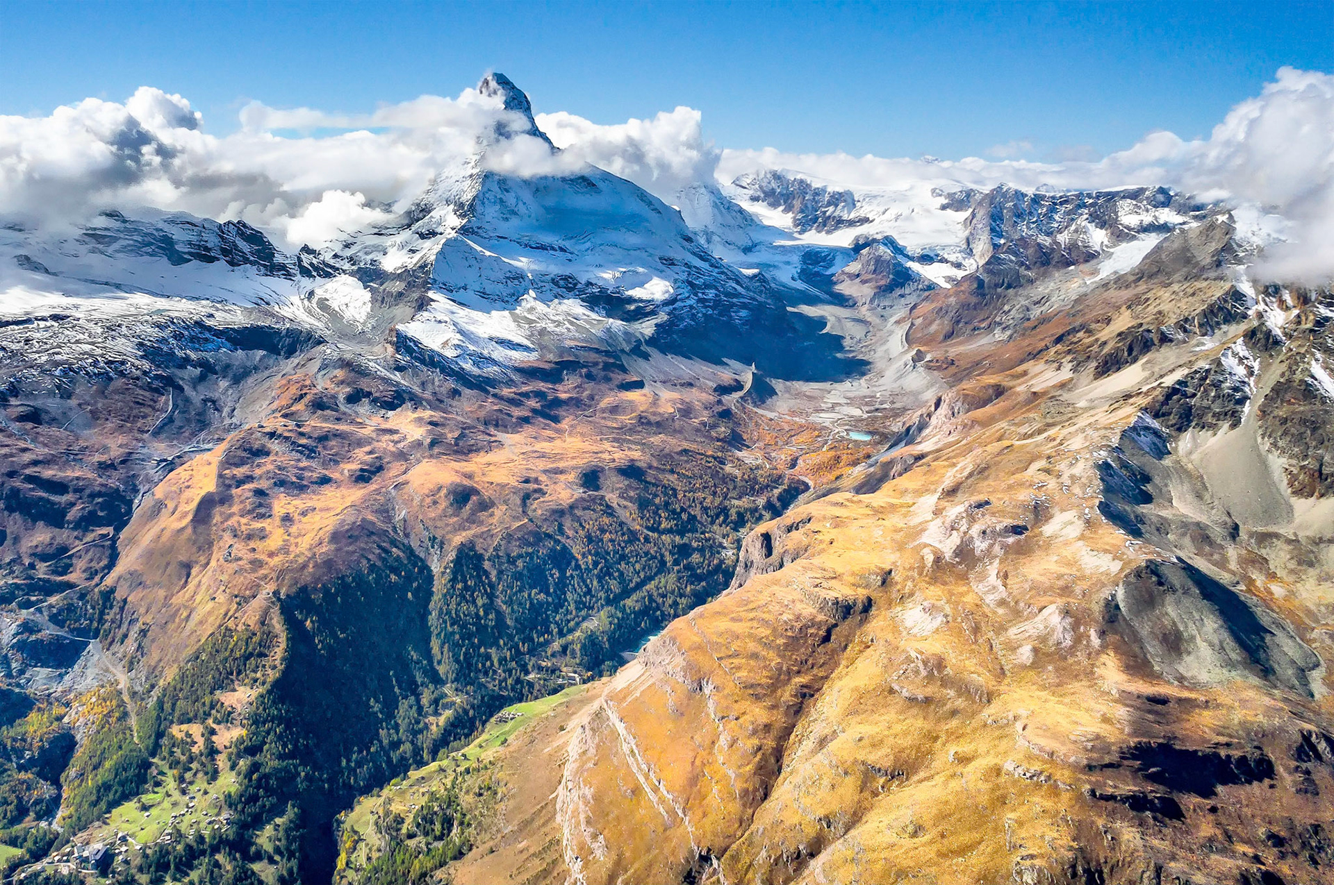 The Matterhorn, (4,478 m = 14,692 ft), is an iconic geologic feature located on the border between Switzerland and Italy. From a helicopter above Zermatt, magnificent views can be seen extending along the Pennine Alp chain. Here the Matterhorn is shrouded by a cloak of incoming storm clouds.