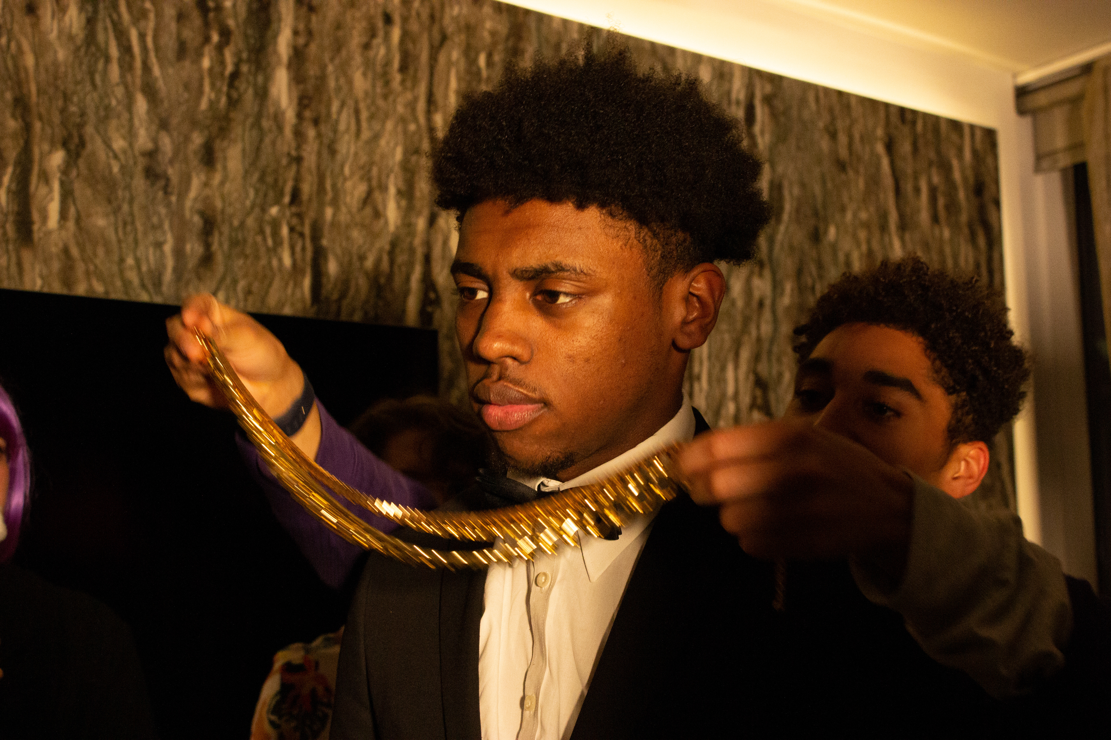 I demonstrate the action of placing a gold chain around the lead