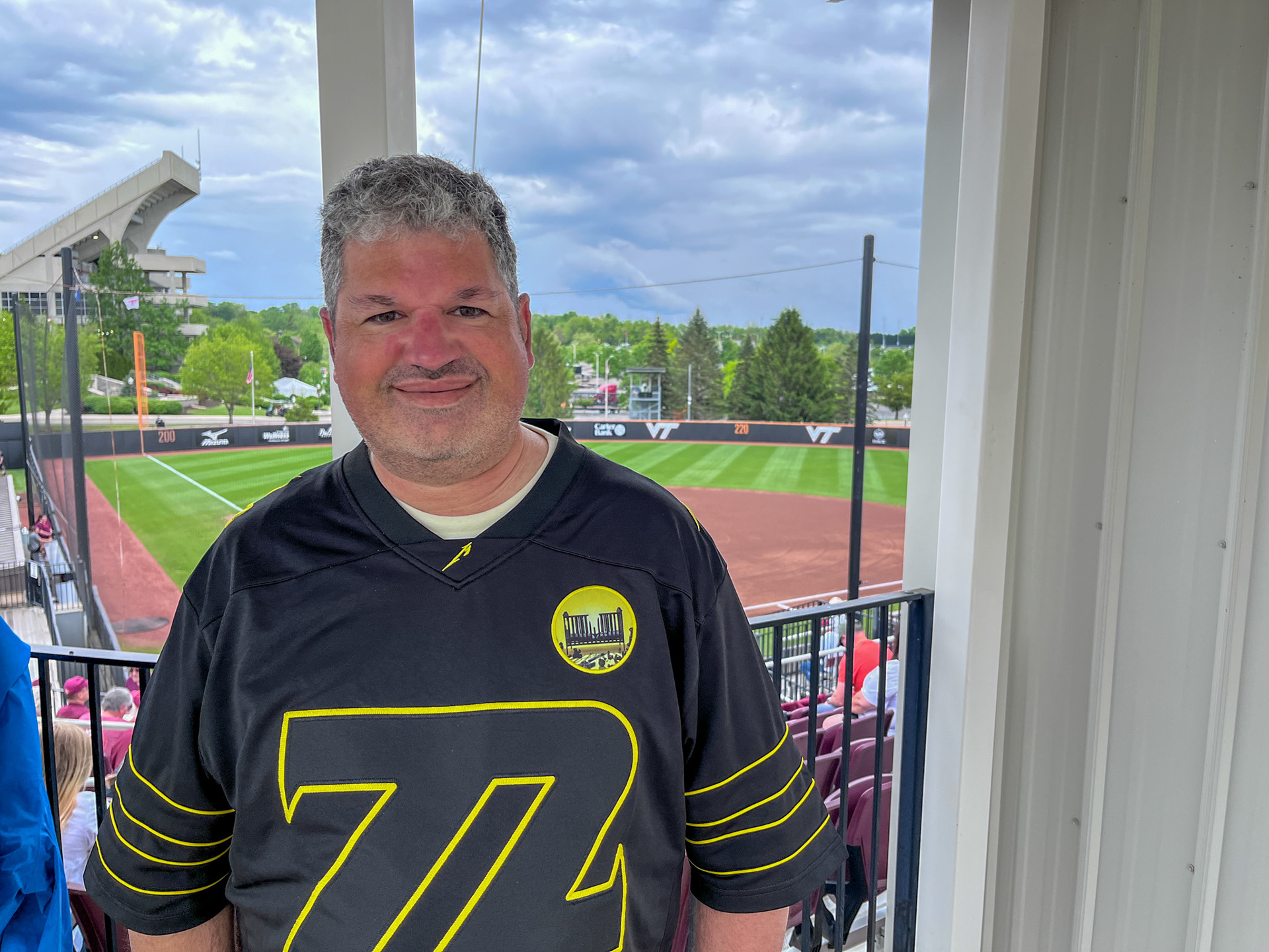 BLACKSBURG, Va., May 3, 2025 — Salas: Damian Salas, Virginia Tech’s assistant athletics director for digital and internet strategies, poses in front of Tech Softball Park. Photo: Sam Mostow