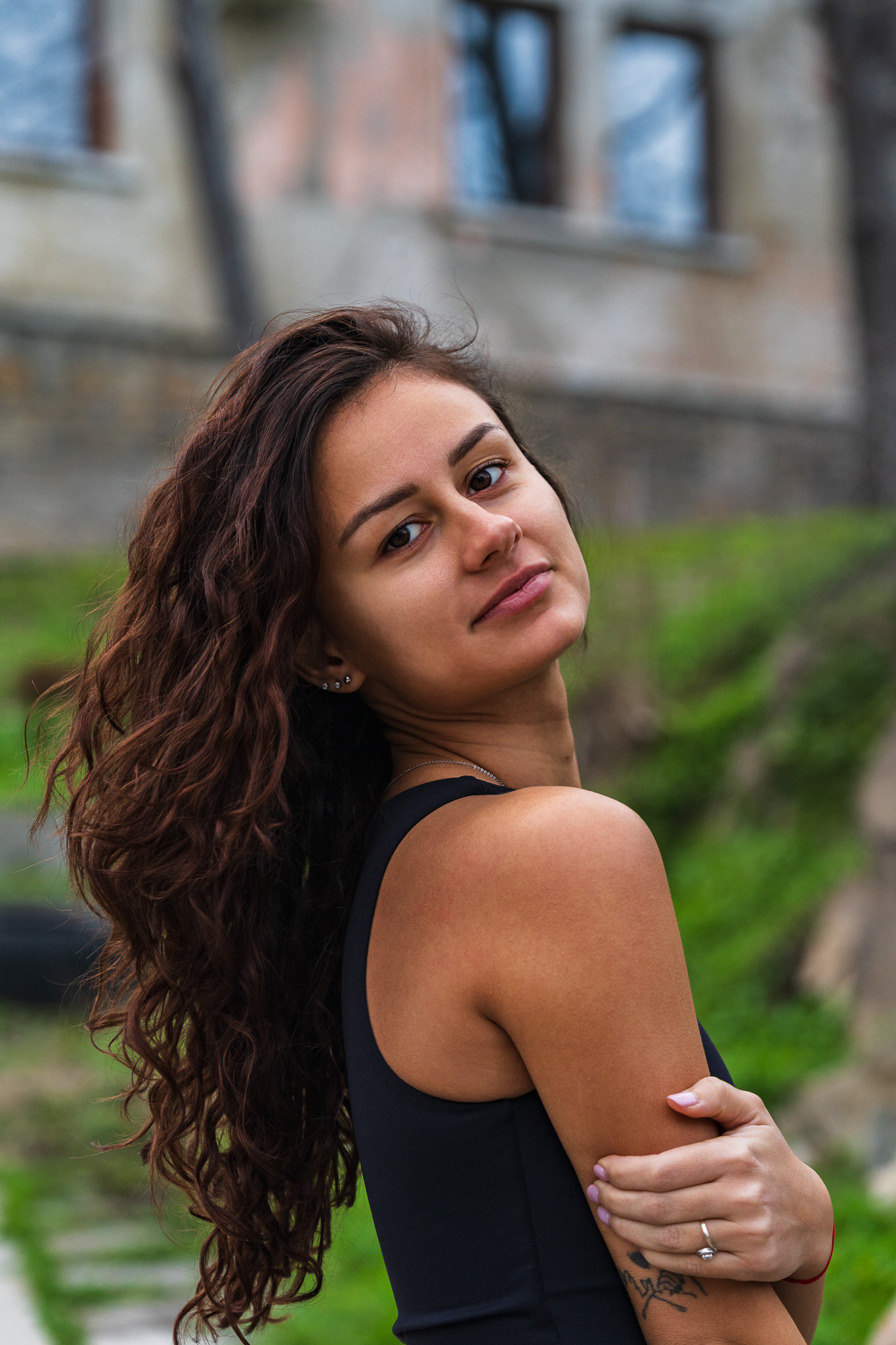 Close-up fashion portrait of a curly haired model in a black top with a warm natural expression. High-end portrait photography by Tenyo Barbolski, Cambridgeshire.