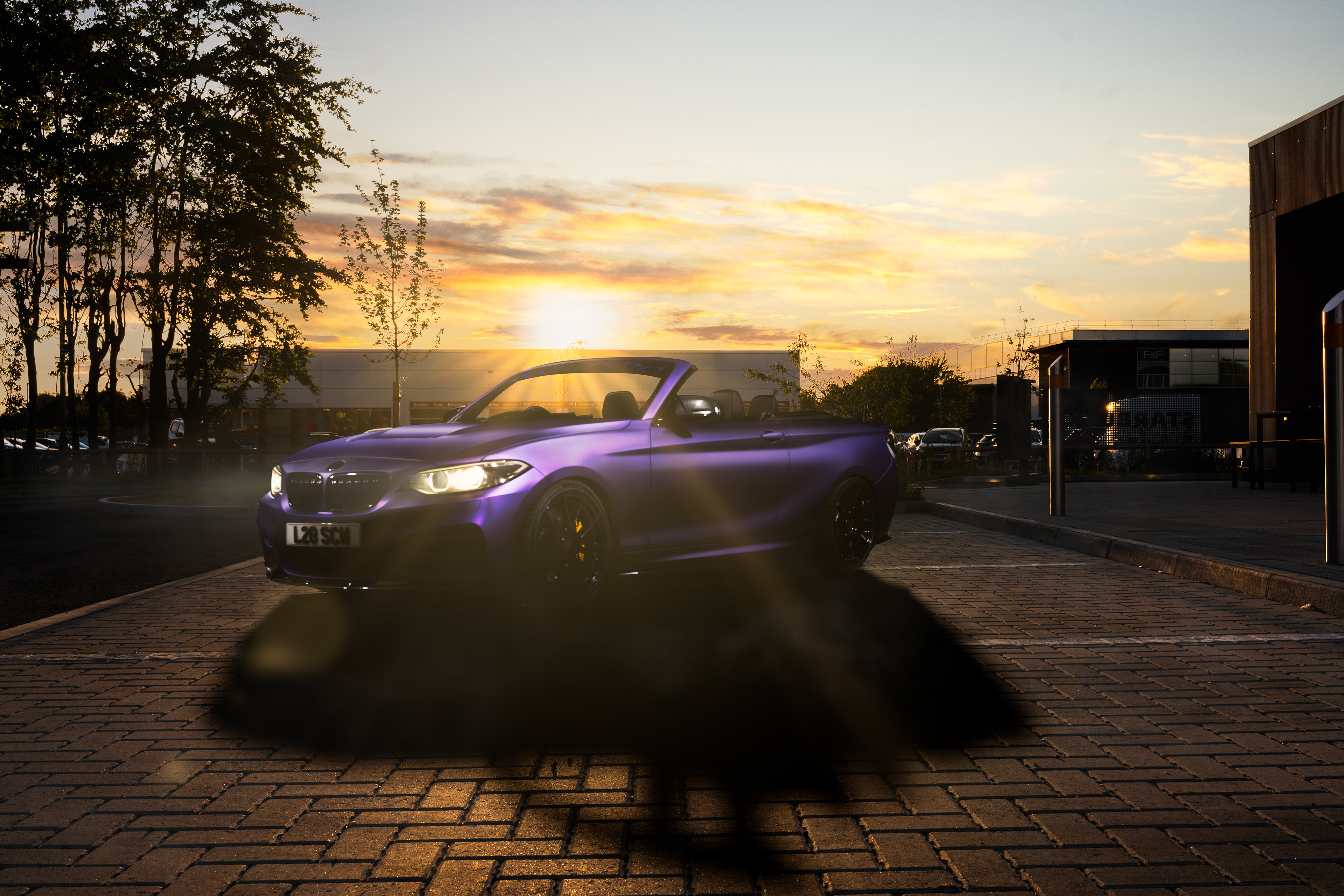 Cinematic Golden Hour automotive landscape portrait of a purple BMW 240i convertible at sunset. This high-end edit features precise light grading, enhanced paint textures, and natural reflection balance for commercial and lifestyle car photography. Shot in the UK/Cambridgeshire