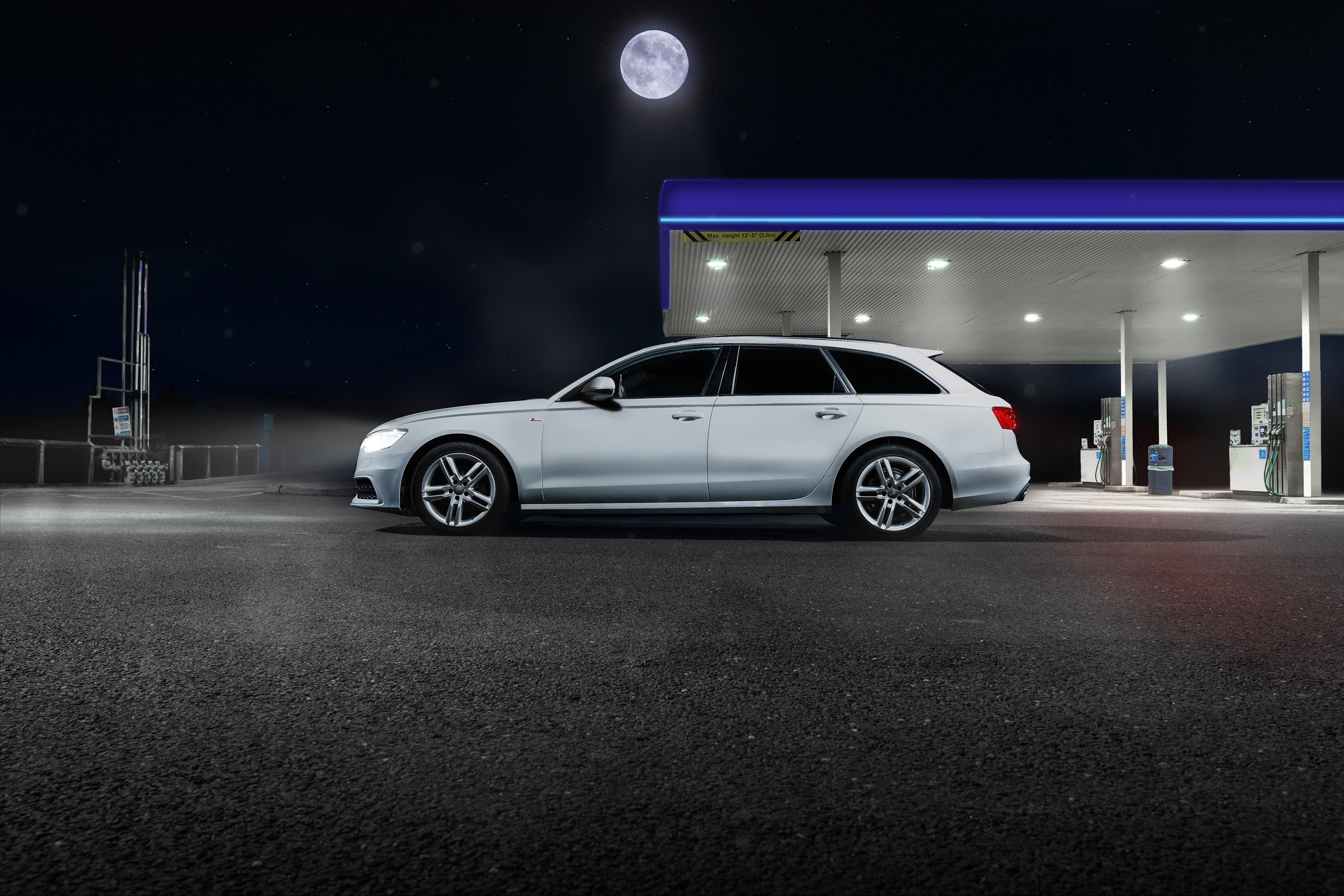 Precision automotive side profile retouching of a white Audi A6 Avant under nocturnal overhead lighting. This technical edit perfectly balances highlights, smooths body reflections, and emphasizes the sophisticated lines of the luxury estate car. Specialist automotive imagery by Arcane Media.