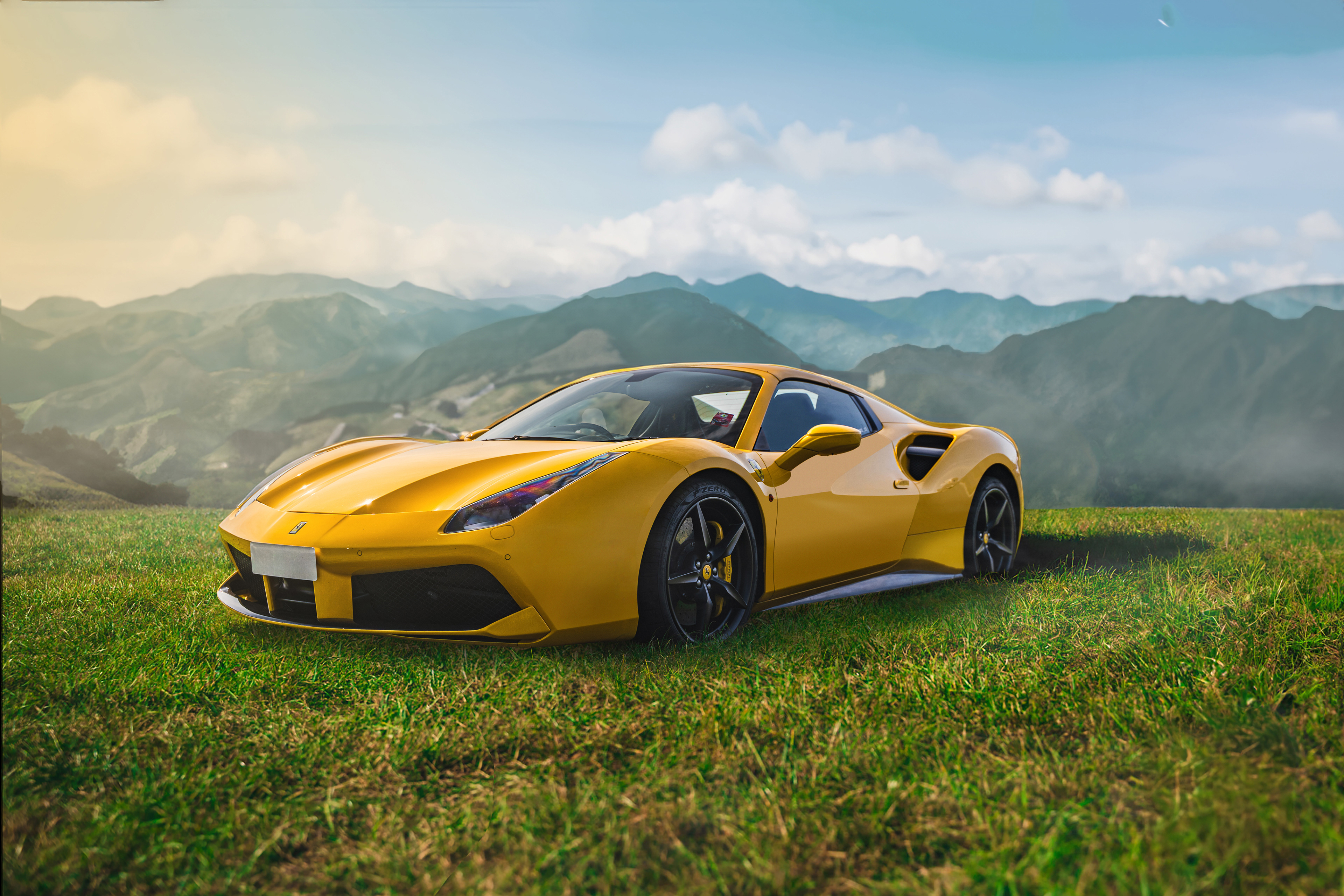 Luxury automotive landscape photography and retouching of a yellow Ferrari 488 GTB on a rolling green mountain pasture. This scenic edit balances natural light, creates perfect paint reflections, and provides expert color correction for an impactful environmental car portrait. International visual storytelling by Arcane Media