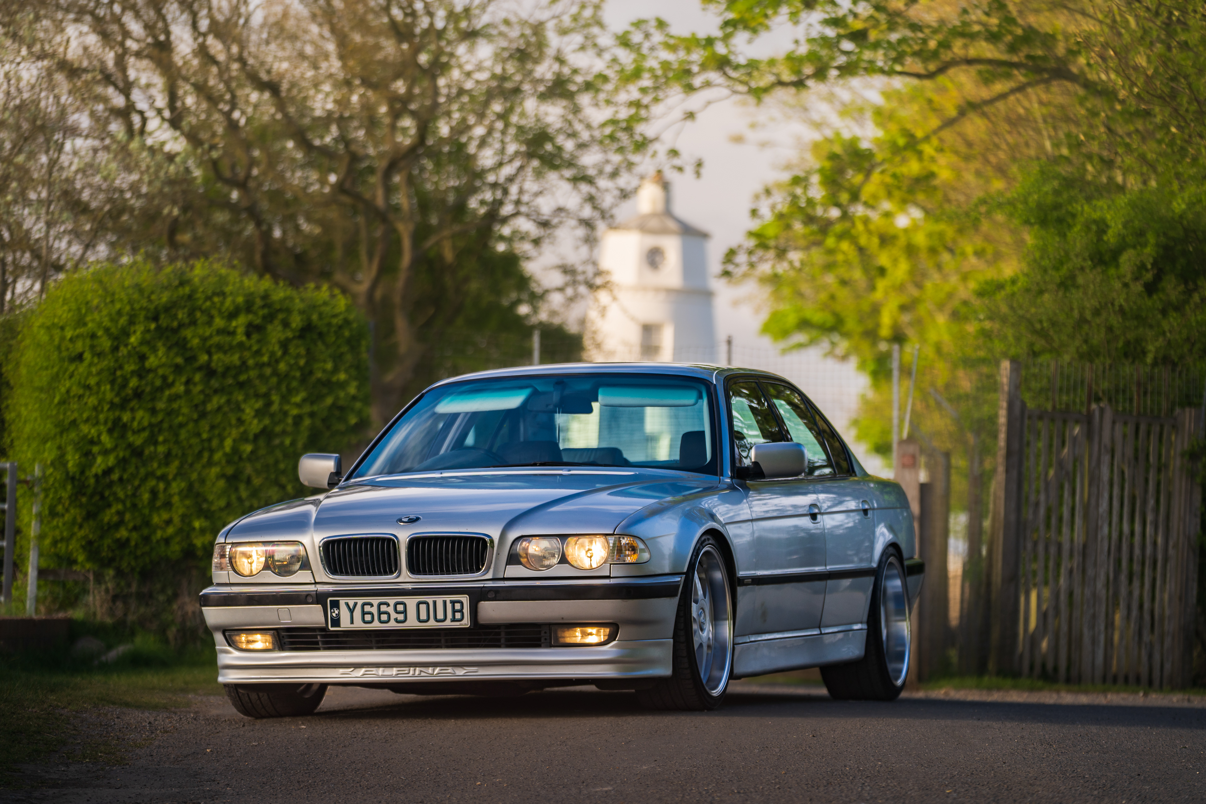 BMW 7 series e38 parked on rural road with natural framing and depth