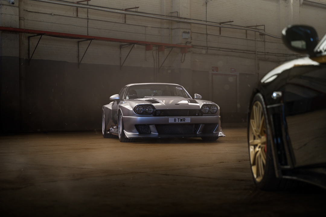 Cinematic interior automotive retouching of a modified classic sedan TWR Supercat in a moody garage setting. This expert edit demonstrates mastery of low-key lighting, depth-of-field control, and detail preservation for atmospheric automotive storytelling. Shot in the Bicester motion during Pistonheads annual meeting.