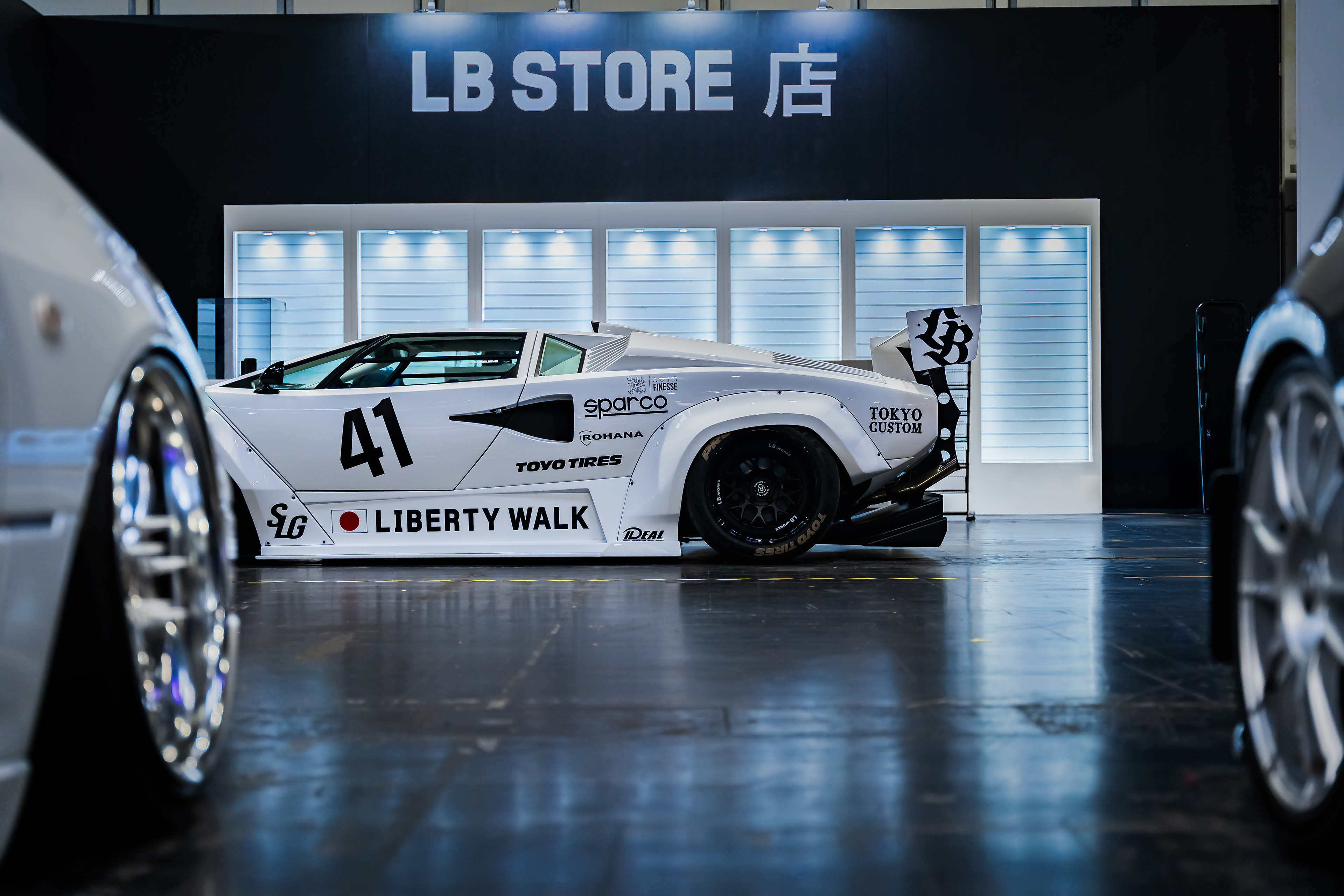 Side profile of Liberty Walk widebody car Lamborghini Countach in exhibition space with reflections at Gravity Show