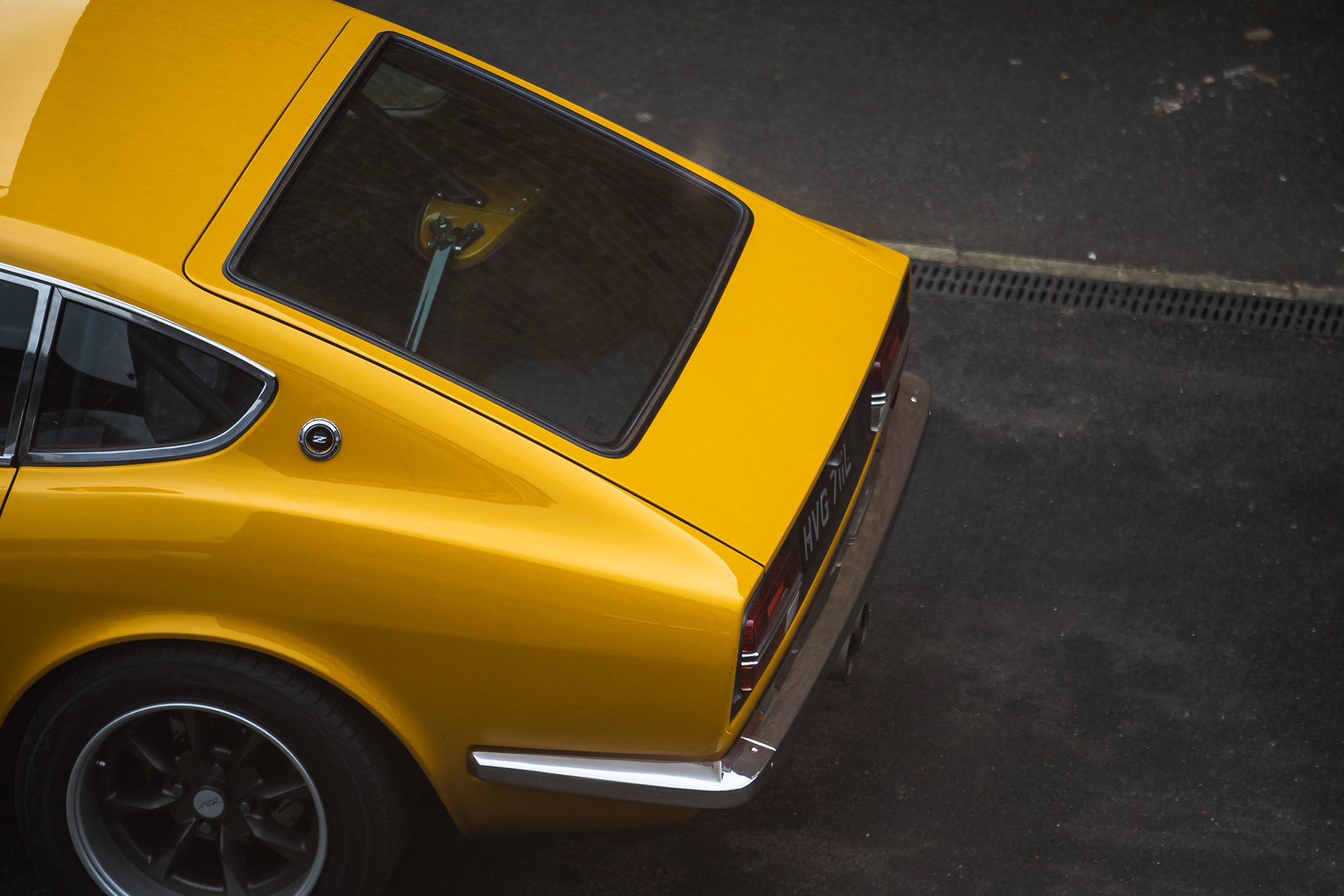Top angle view of yellow Datsun 240z rear end of the car