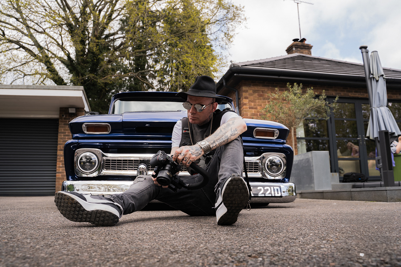 Heritage automotive portrait of a male model seated in front of a classic blue Chevy truck. Capturing the character of the subject and the soul of the vintage vehicle.