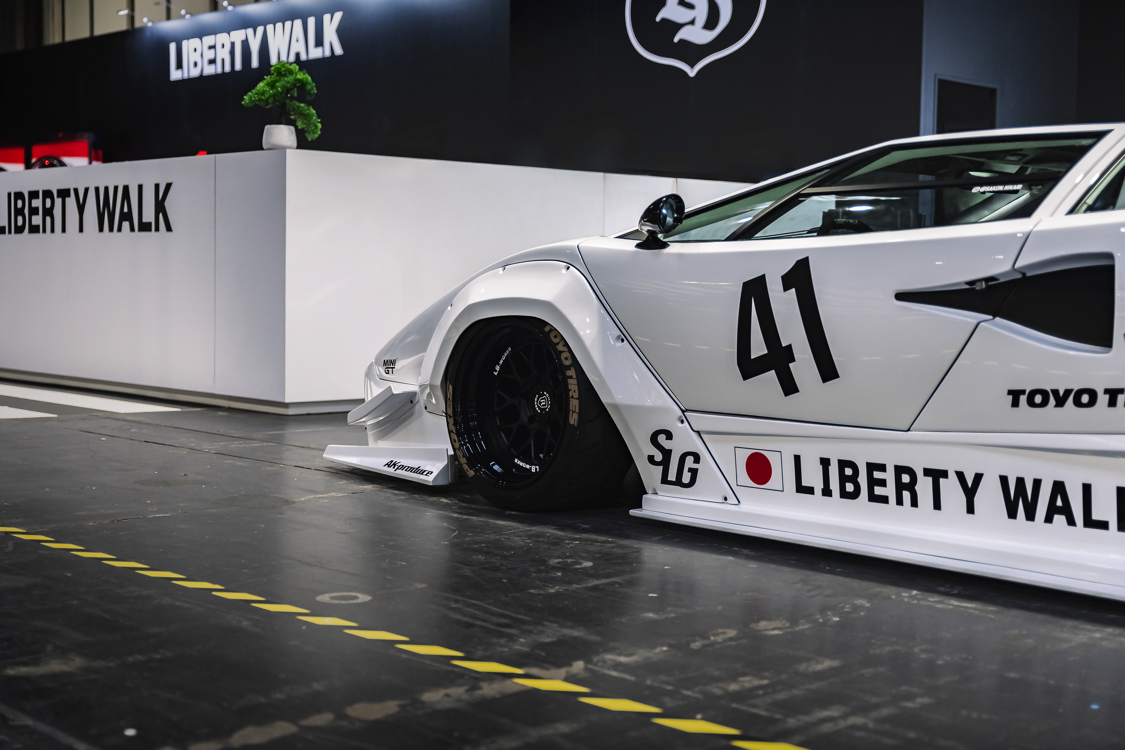 Rear angle of Liberty Walk car Lamborghini Countach with aggressive stance and sponsor livery at Gravity Show