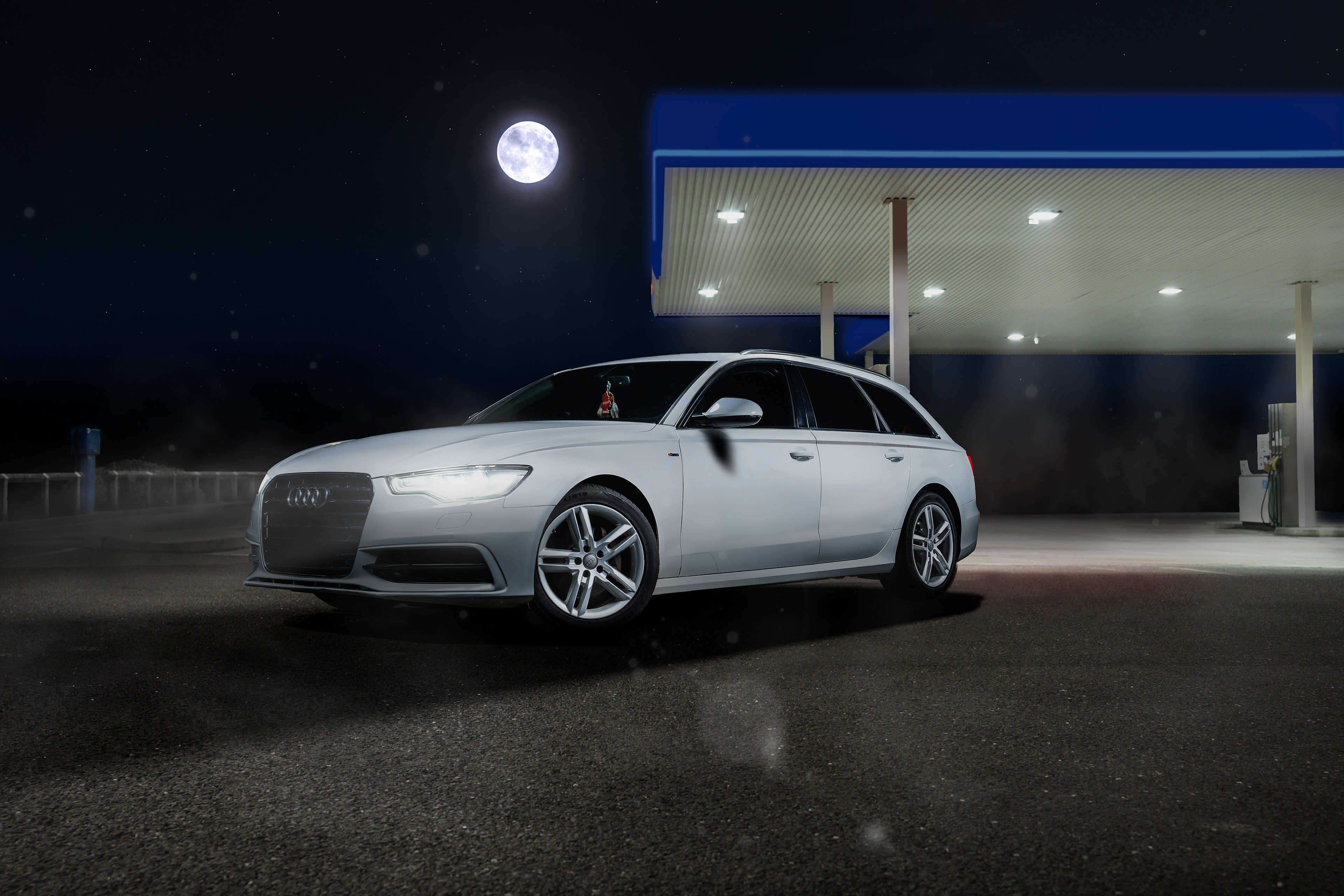 High-end automotive retouching of a white Audi A6 Avant at a lit gas station under a night sky. This professional edit features advanced light blending, clean reflections, and technical detail enhancement for luxury commercial photography. Visual storytelling by Arcane Media.
