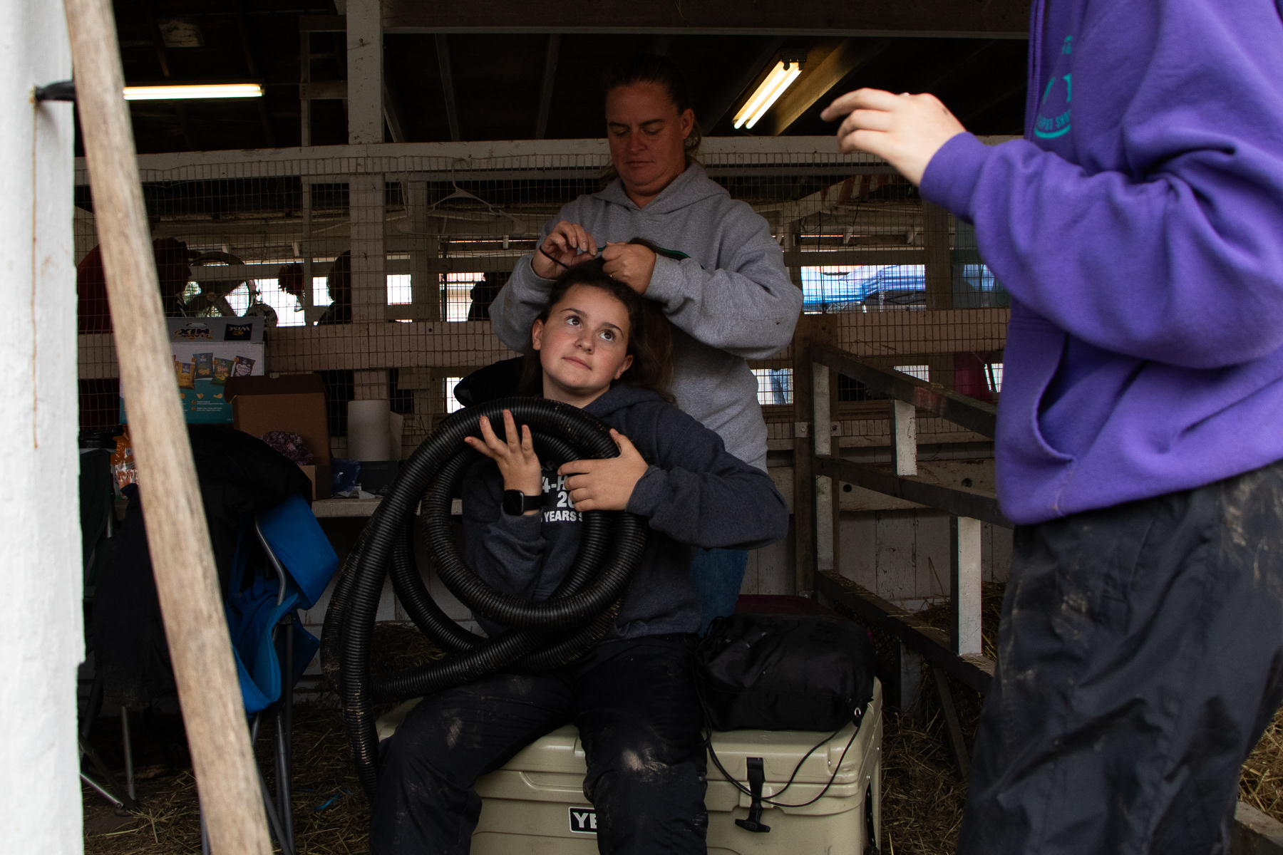 Brenna’s mother helps do her hair for the 4-H market steer show.