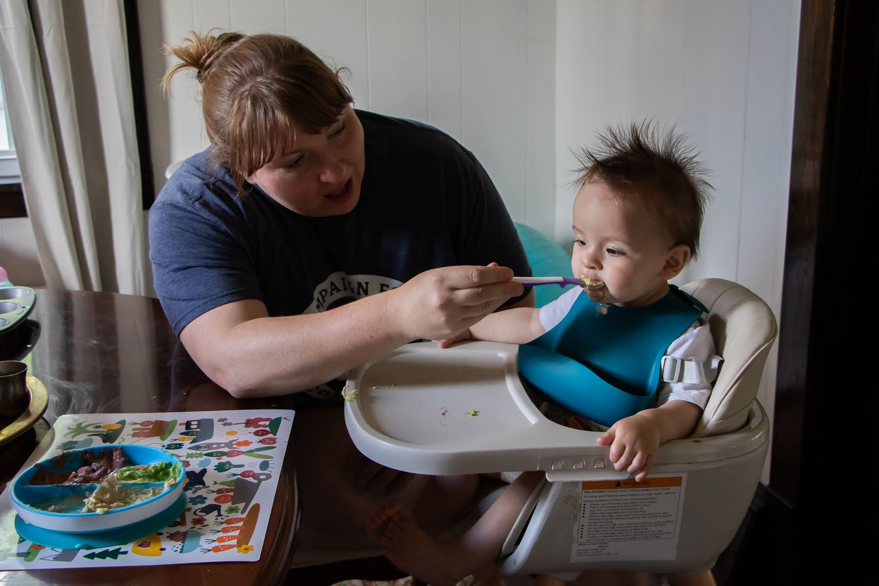 Isabelle and Issac feed their son, Hector, dinner after a day of work