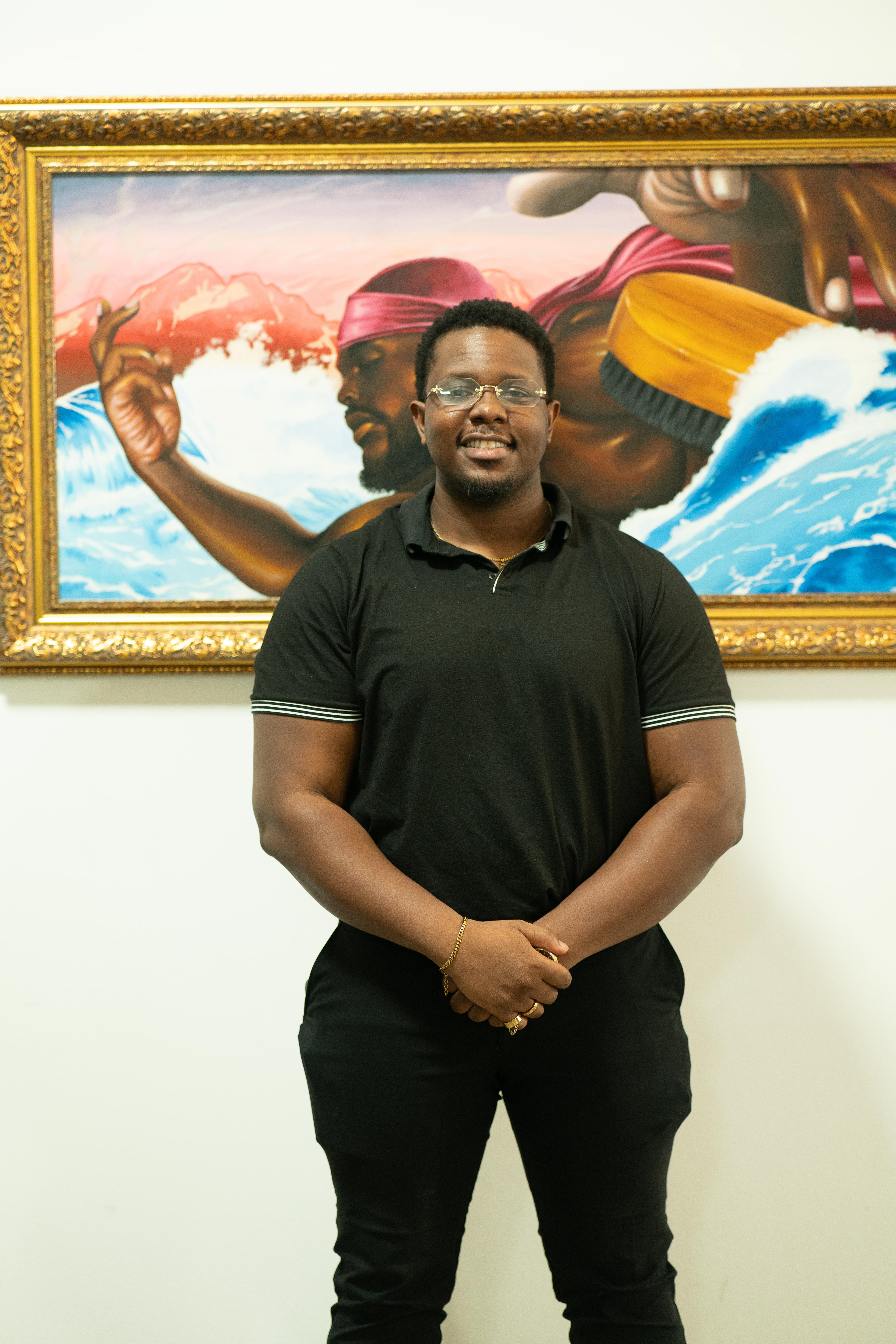 Huey Dynamite poses in front of his painting during his solo art exhibition in Dallas, TX