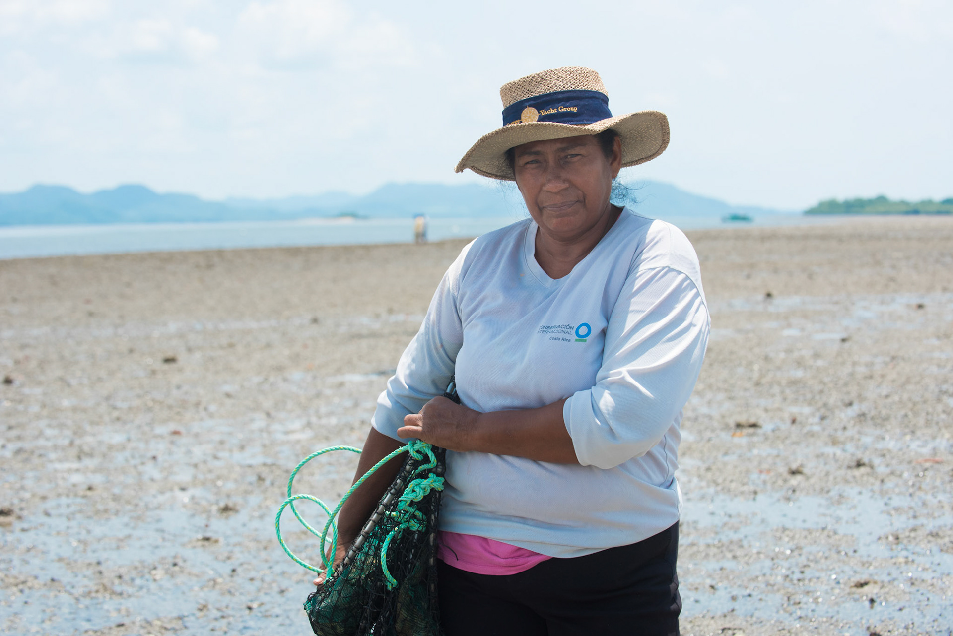 24-junio-2017. Este miércoles 24 de junio visitamos la zona de Puerto Palito en Costa Pajaros, Puntarenas. Desde los años 80, Doña Siday Arias, en conjunto con la Universidad Nacional, han dedicado tiempo para evaluar las posibilidades del cultivo de las Ostras en el Golfo de Nicoya. Hoy día cuentan con 6 granjas. En Puerto Palito, nos encontramos con un grupo de trabajadores que se encargaban cada uno de su tarea: limpieza, selección de Ostras por tamaño, llevar nuevamente al mar, a las que no cumplían con el tamaño mínimo para la comercialización (6cm), entre otras labores. Fotos: Nina Cordero. En la Fotografía: ella es Eugenia Fernandez, quién se encaminaba a la lancha para devolver al mar la Linterna con las Ostras que no cumplían el tamaño de los 6 cm para la comercialización.