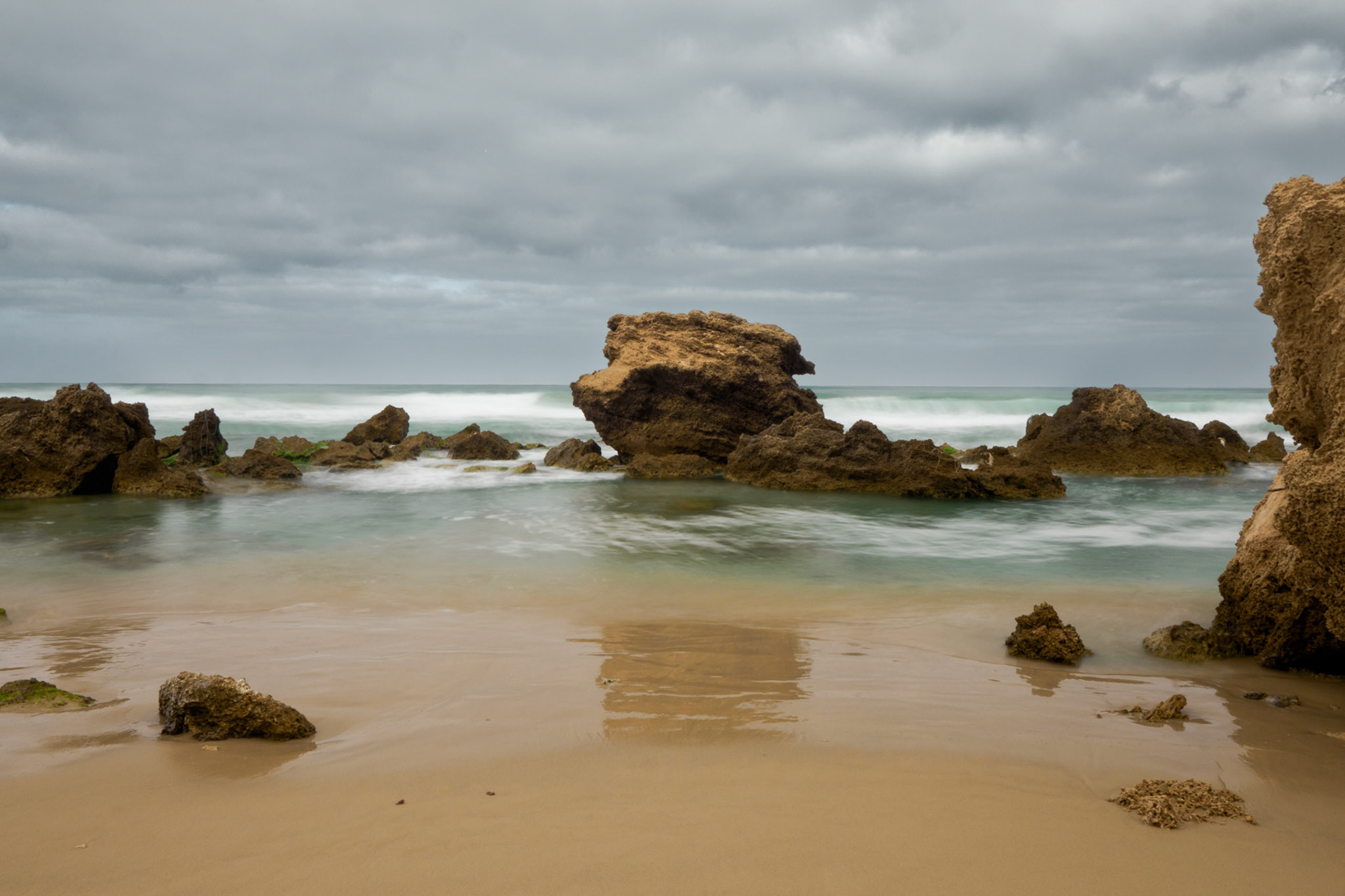 the square rock in the sea on a cloudy and grey day