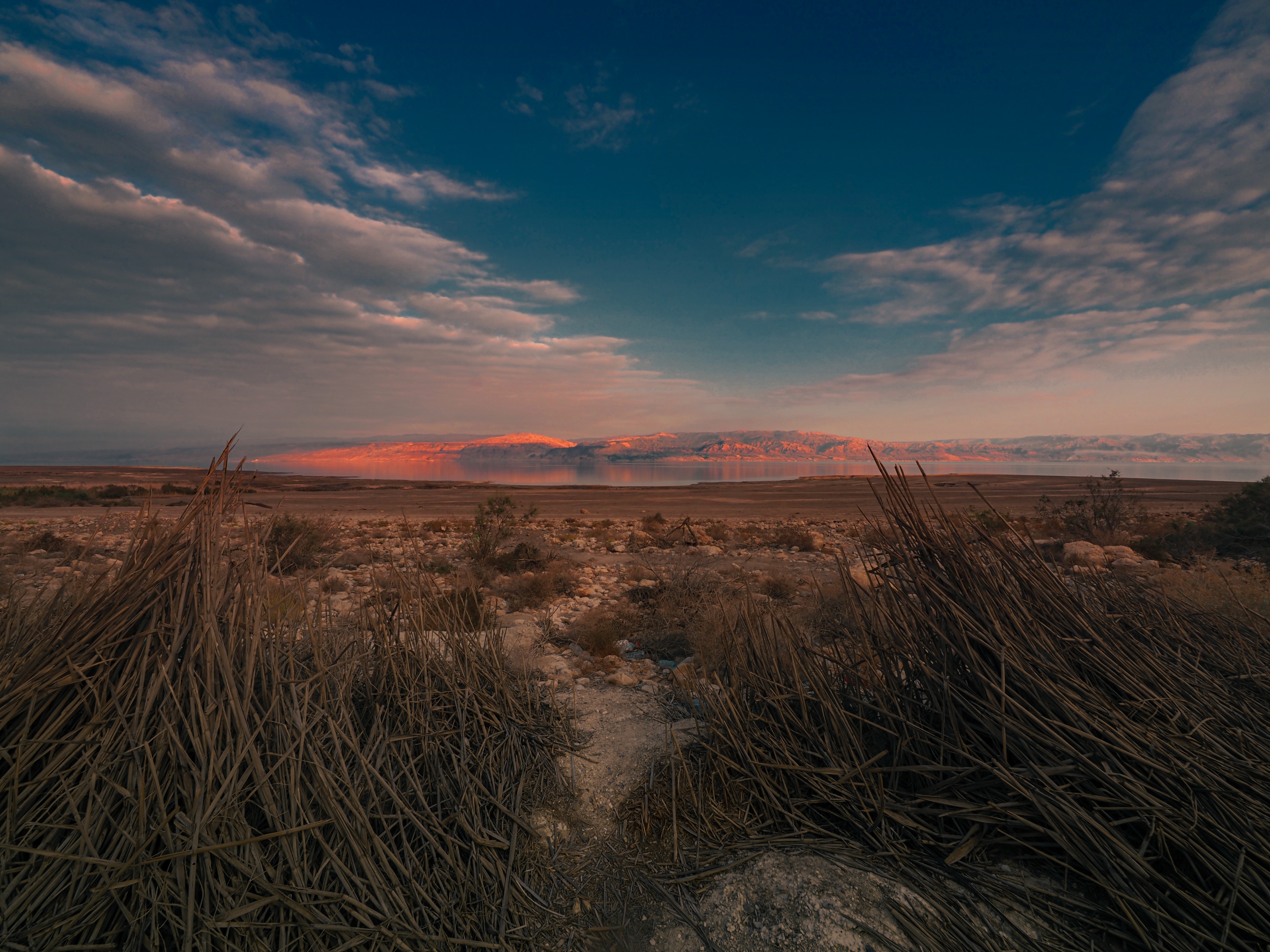 Sunset over the Jordan hills and the southern dead-sea from a low view on. a path toward the water