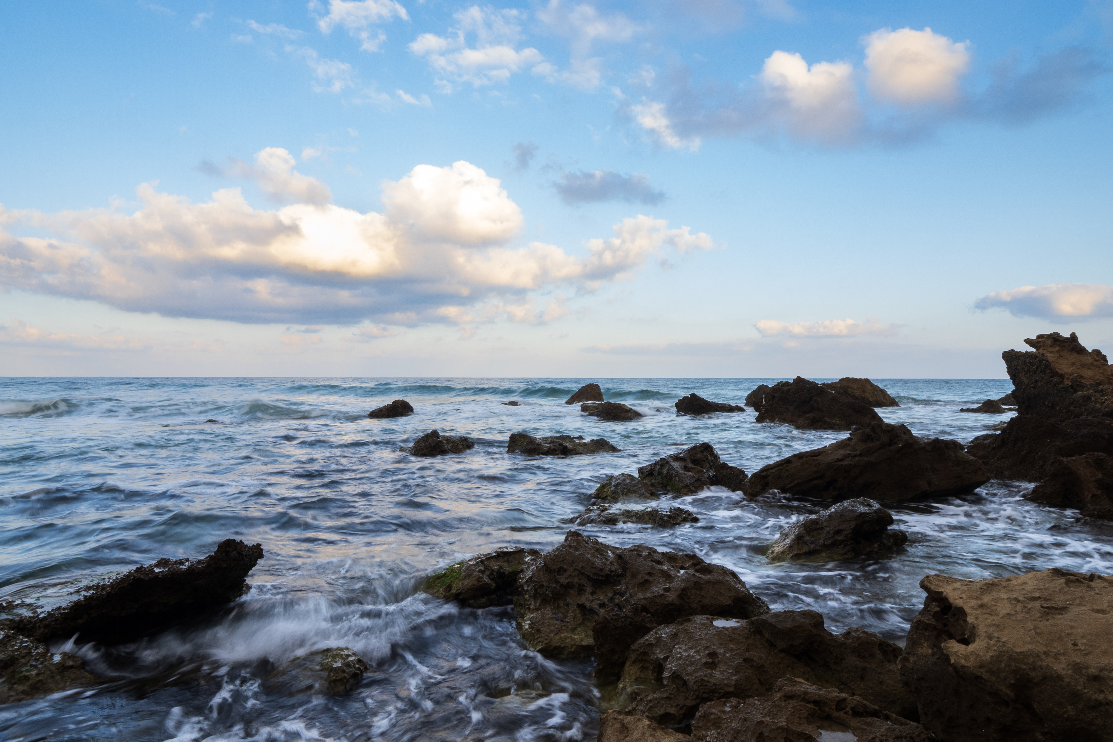 Sunrise time in the beach and national resort of Gdor. rocks and waves with cloudy skies.
