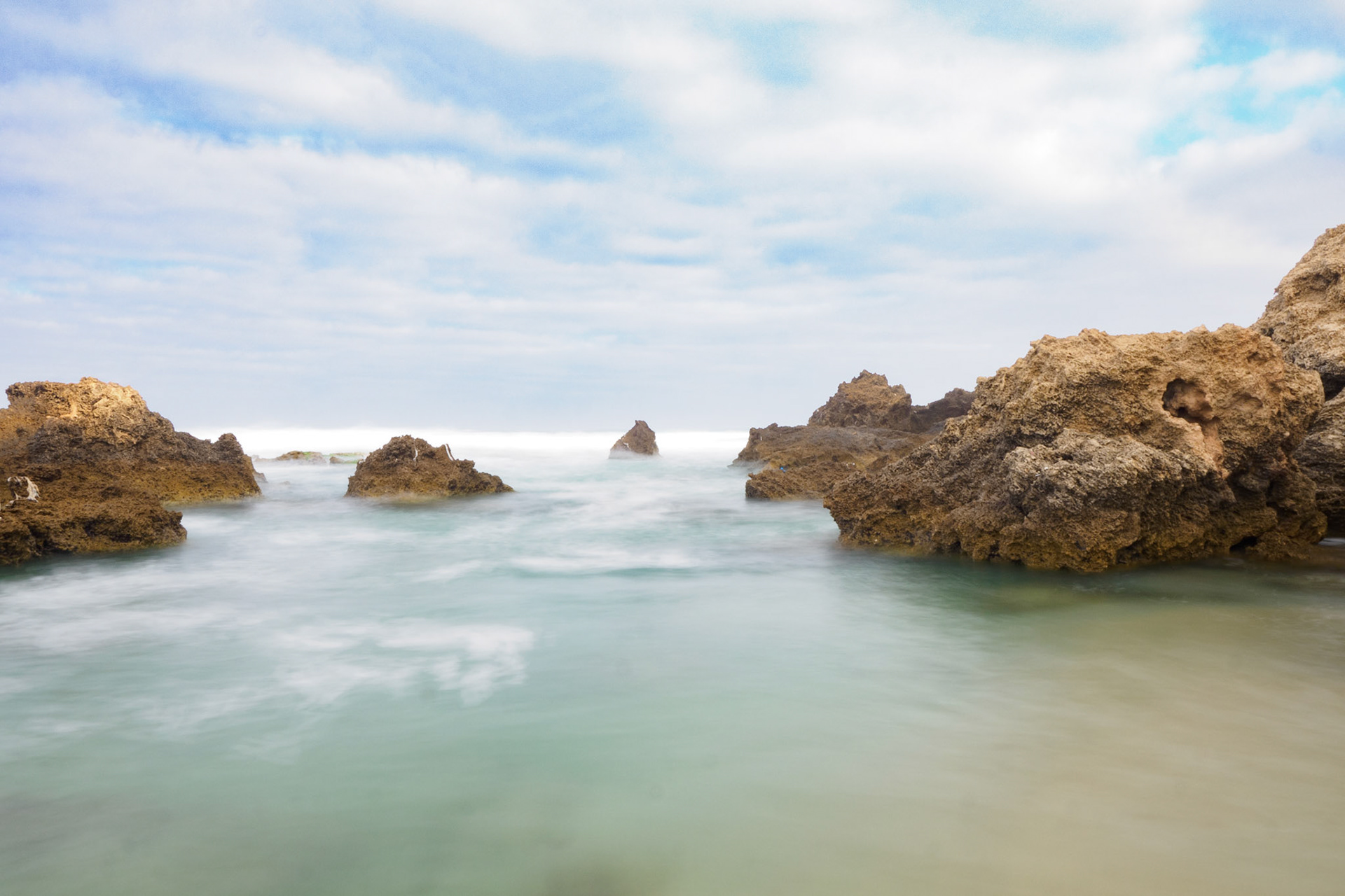 Long exposure over the sea with rocks bumping out from it