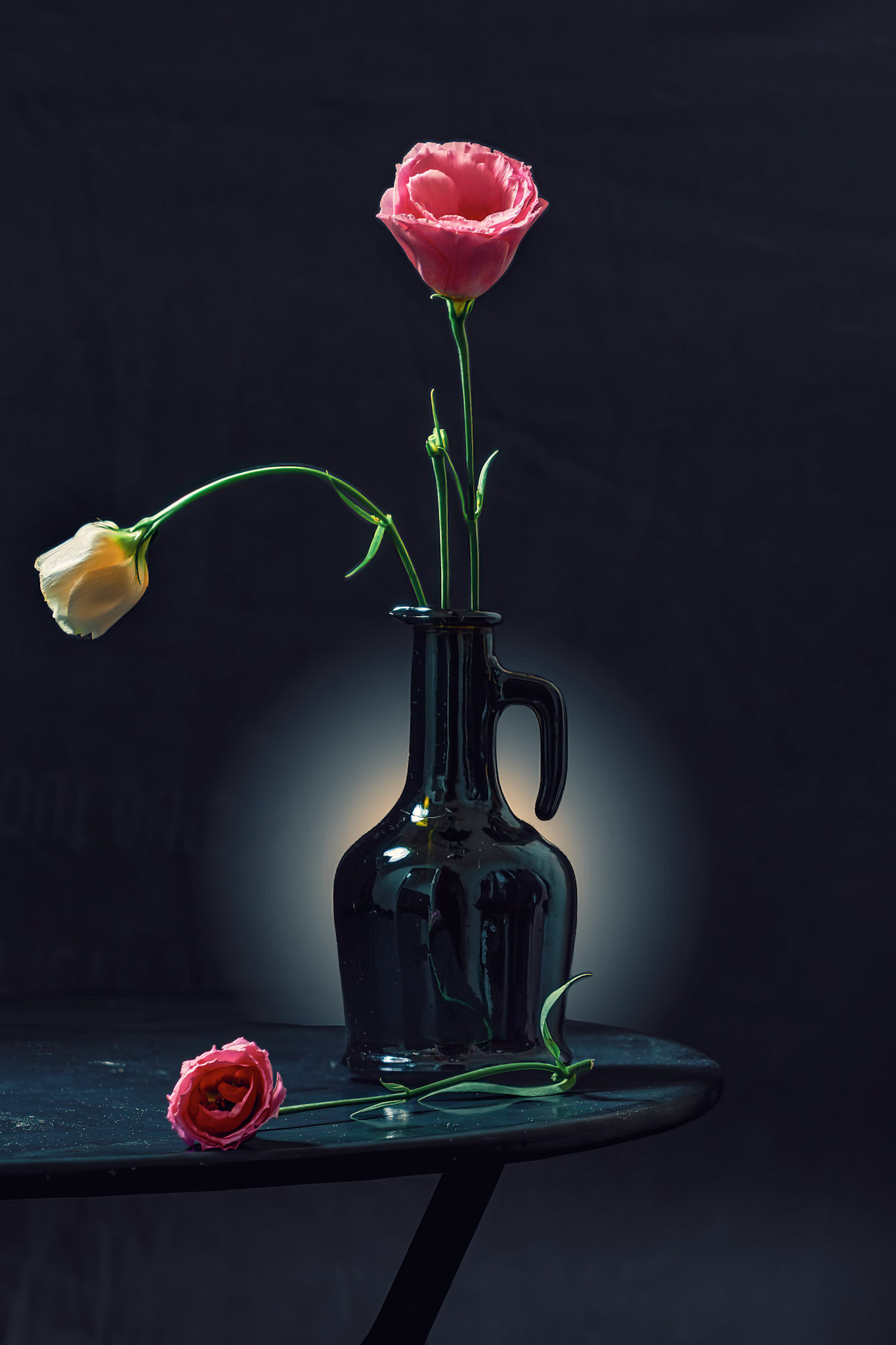 Pink and white Eustoma flowers in a black vase