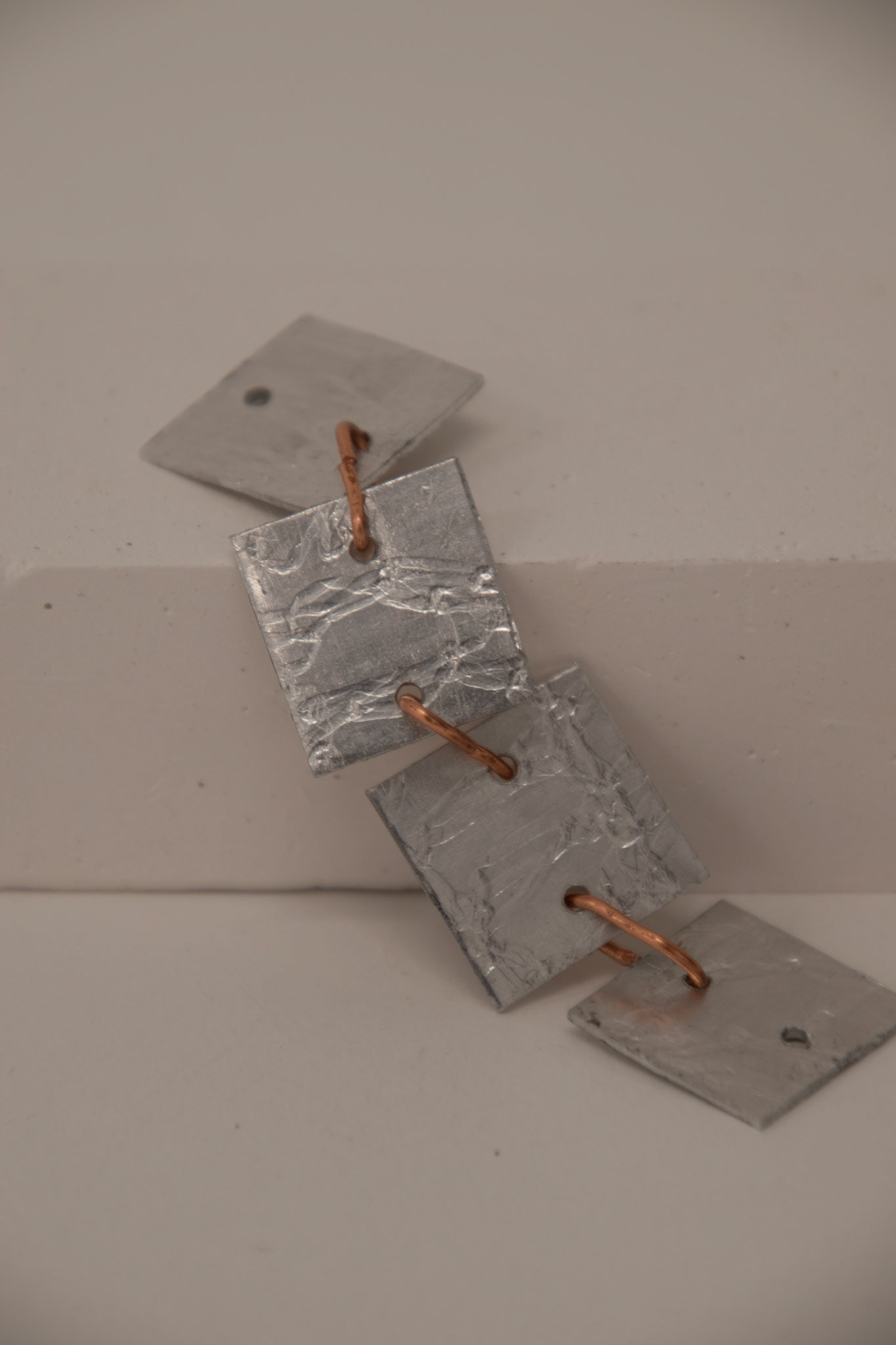 Rolled aluminium linked with copper jump rings exploring flexible movement in 2 planes