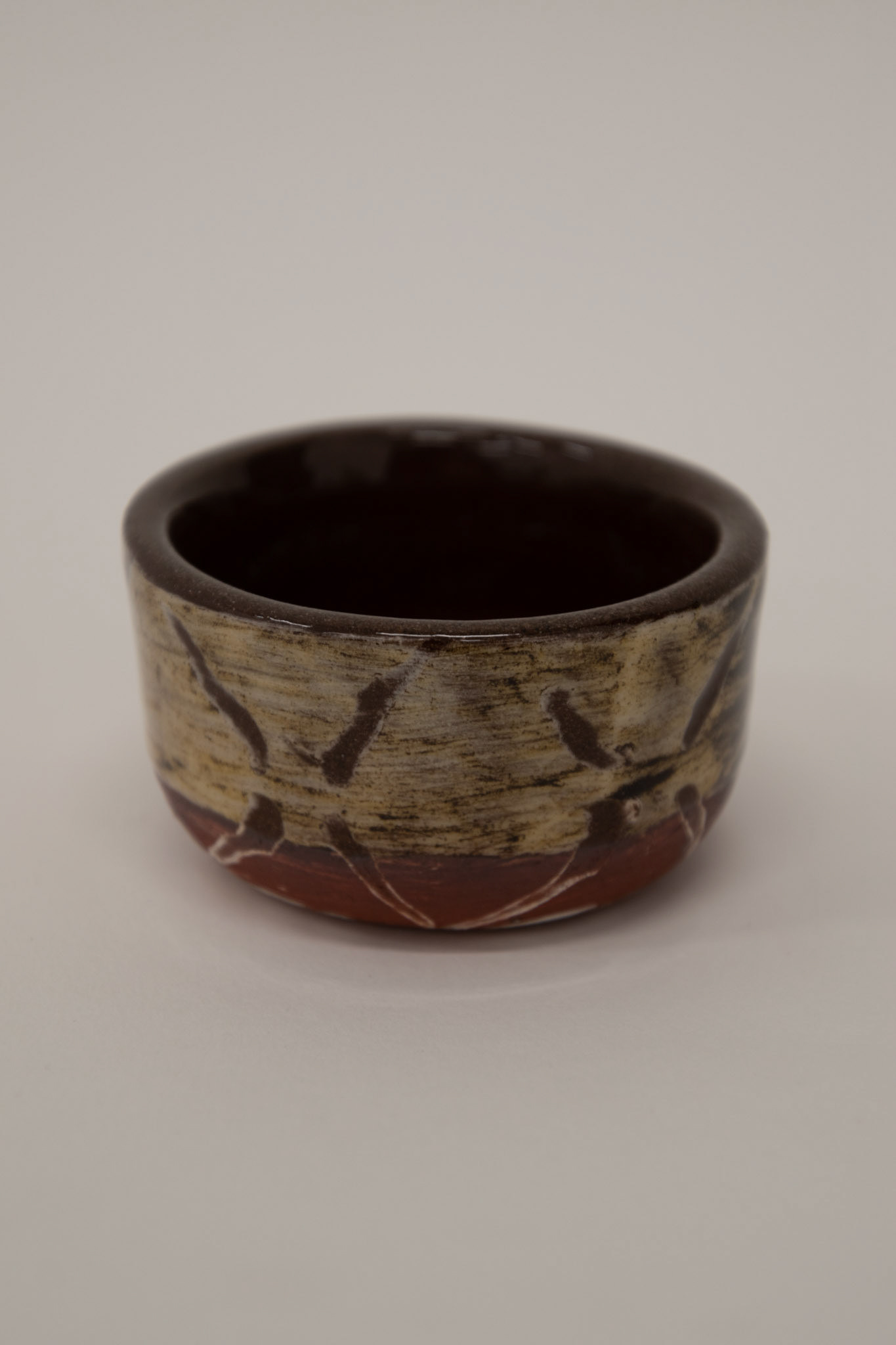 Clear shiny glaze on top of sgraffito white and red slip from frottage